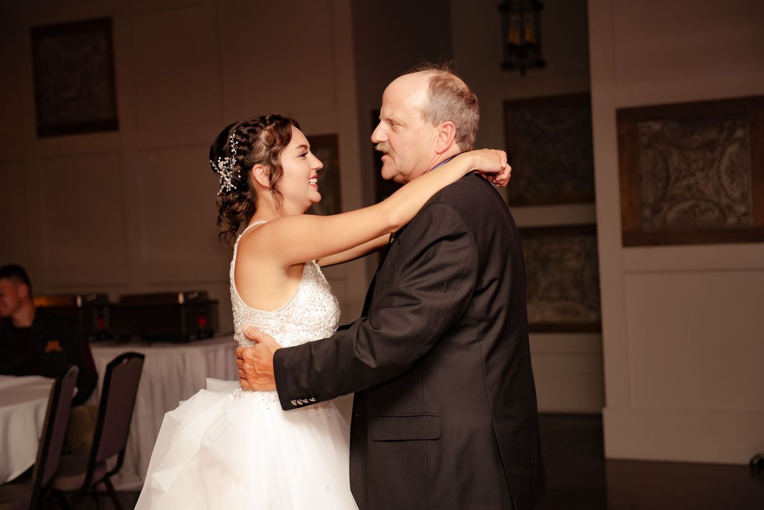 A joyful dance shared between two people at a wedding reception with warm lighting.
