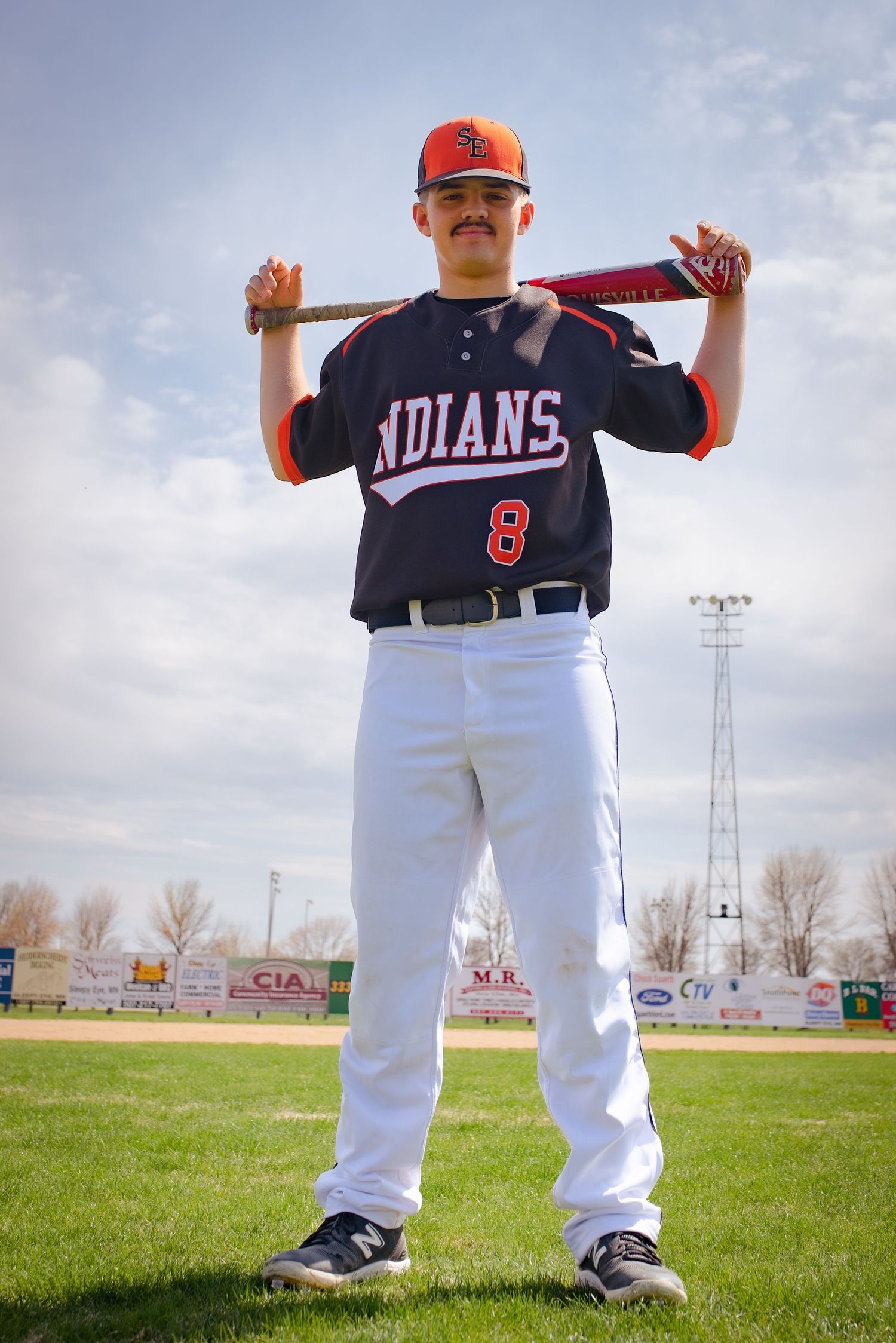 Baseball player in Indians uniform number 8 poses with bat on field during practice.