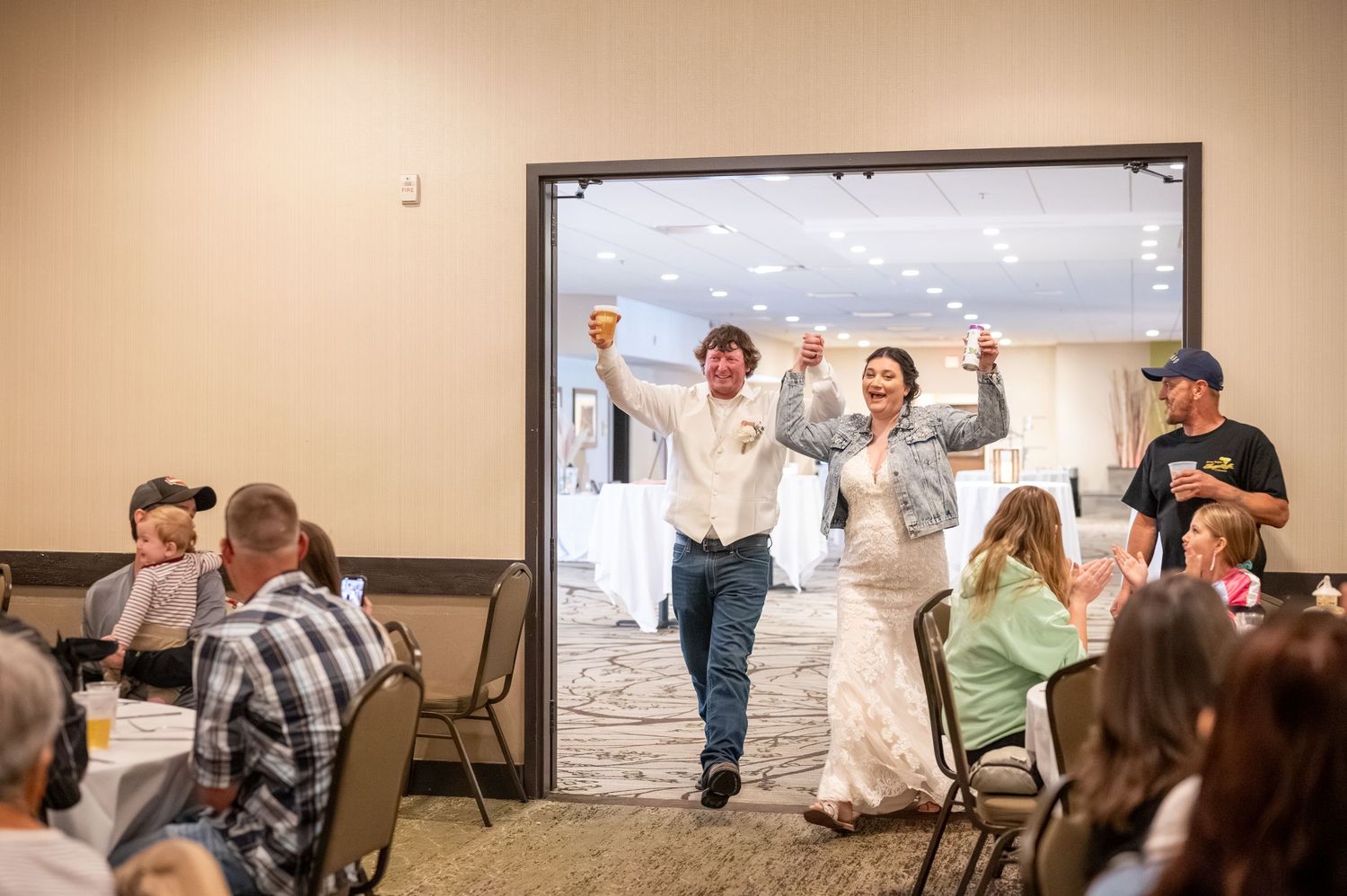 Wedding guests cheer and celebrate during a reception entrance.