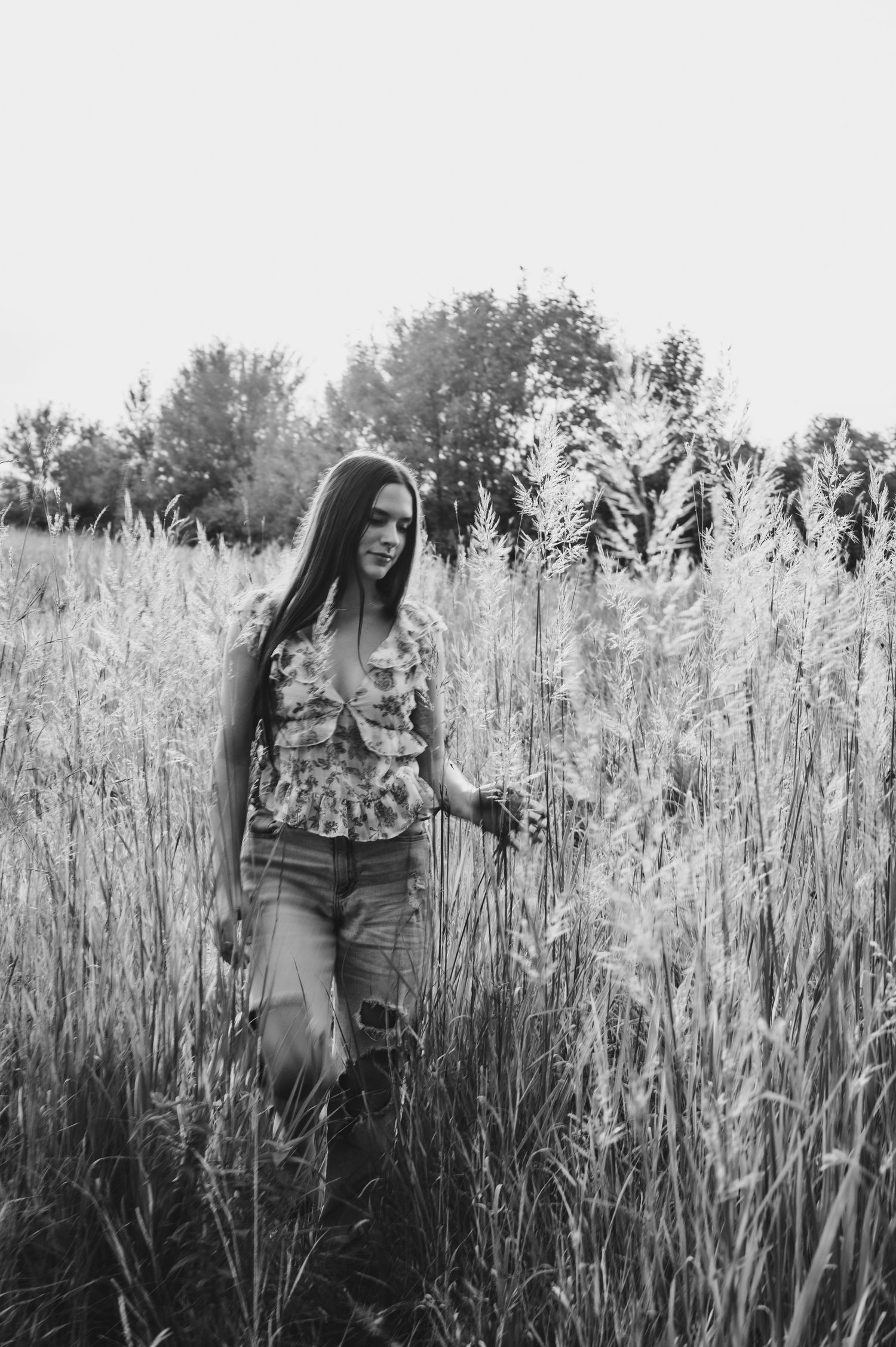 Black and white portrait series in tall grass field with moody artistic composition.