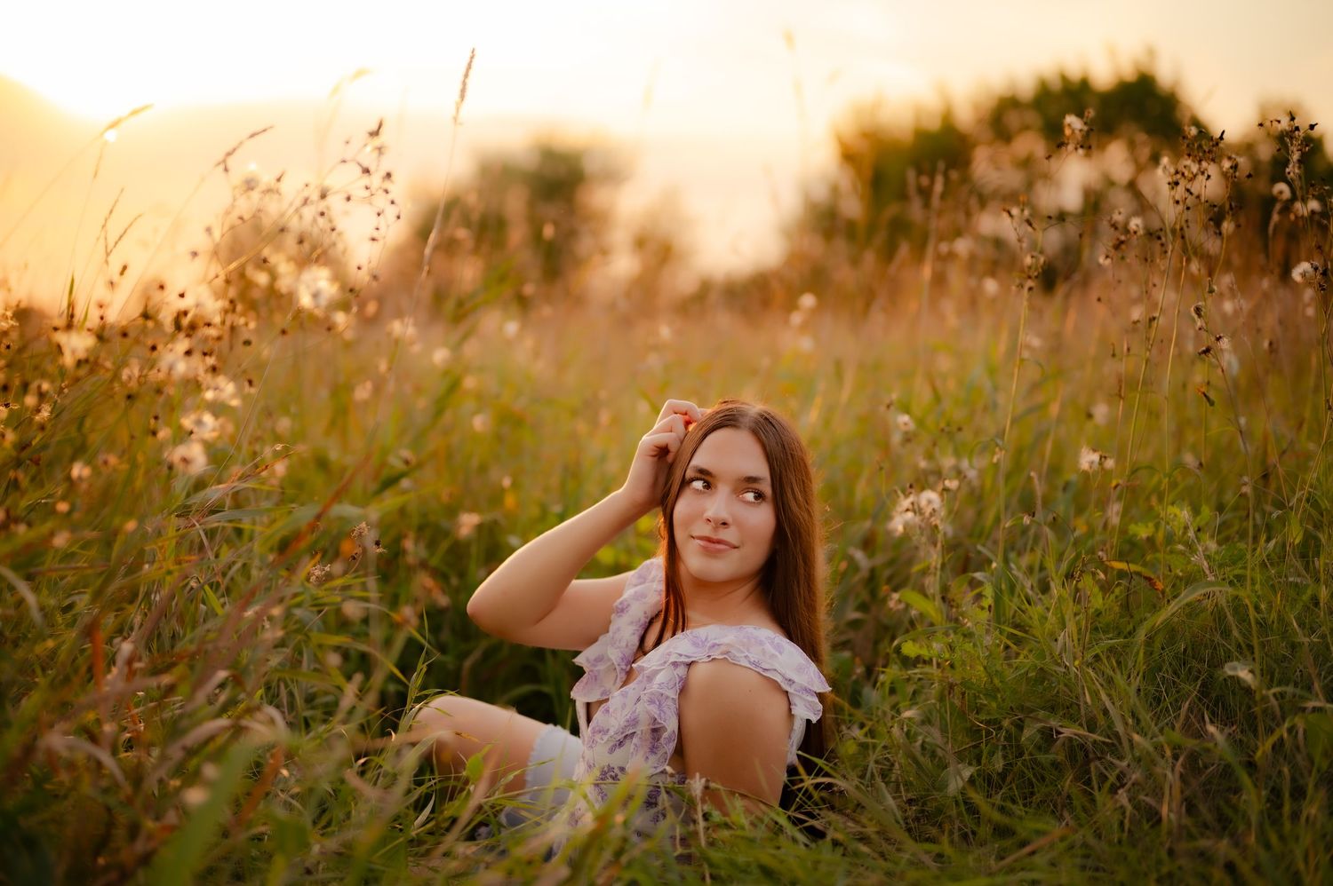 Golden hour portrait photography in a rustic field with tall grass and warm lighting.