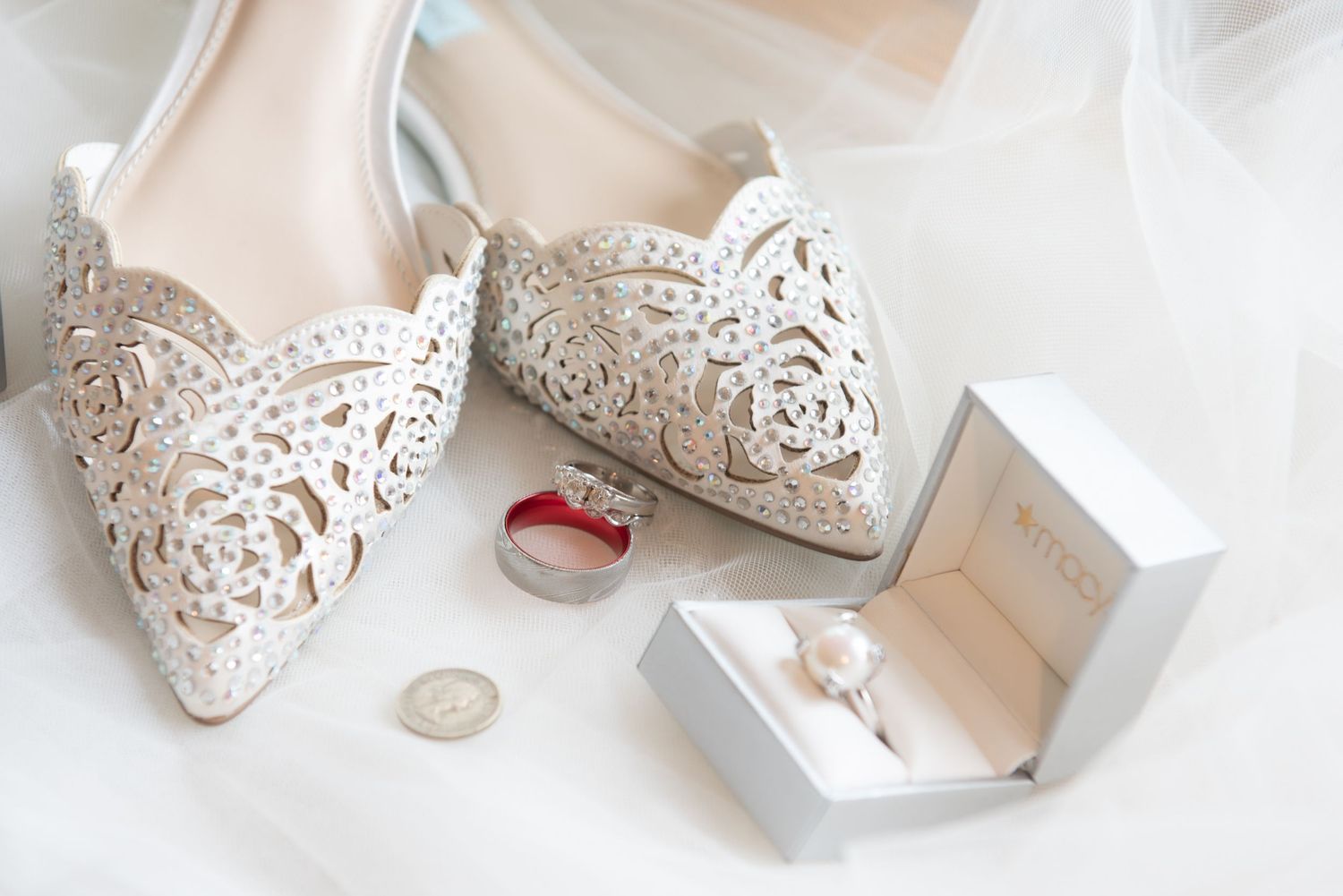 Elegant white lace bridal shoes with wedding rings and jewelry box.