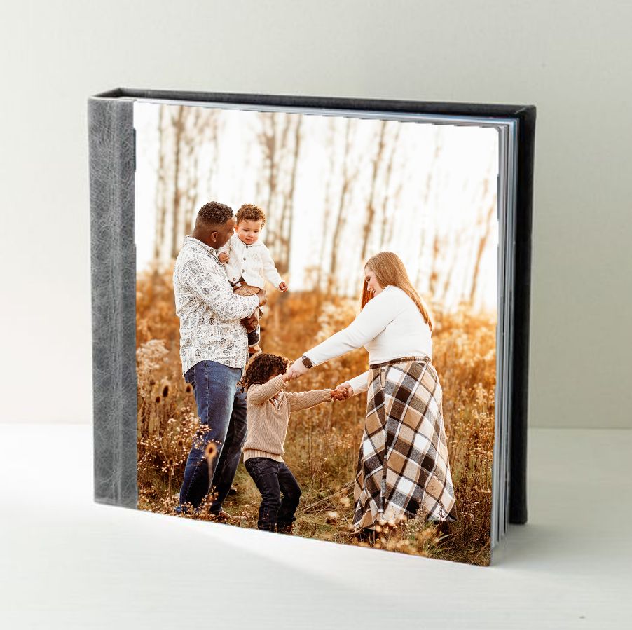 An example of a photo album showing a linen spine and image cover with a family playing in a golden field