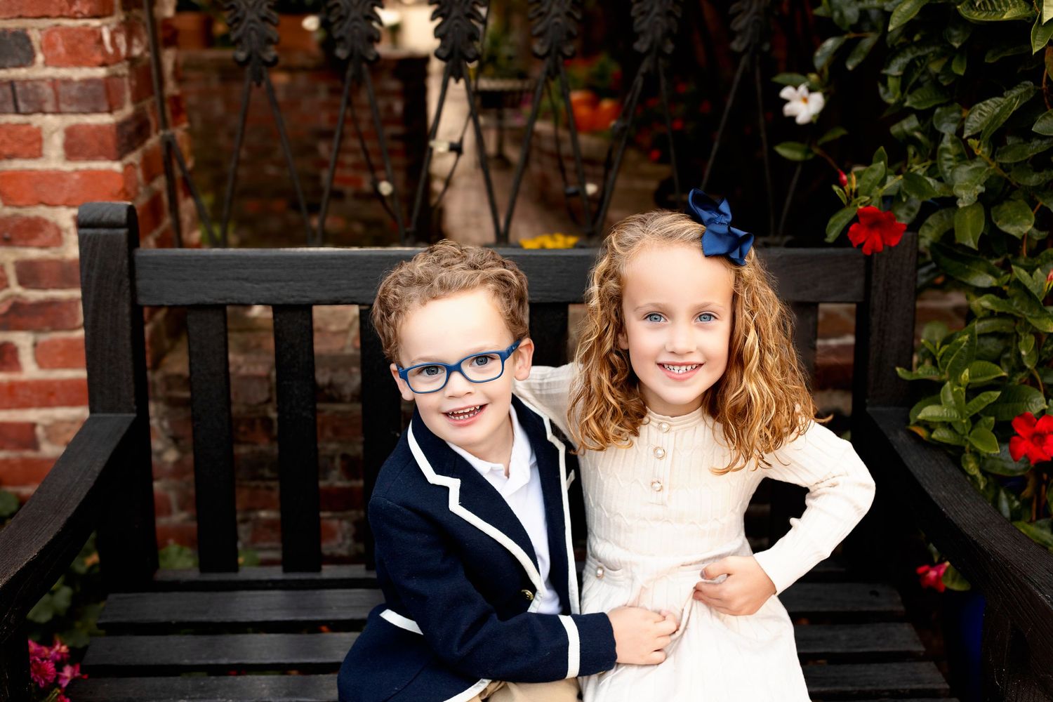 Siblings smiling on bench for urban family photos in Zionsville Indiana