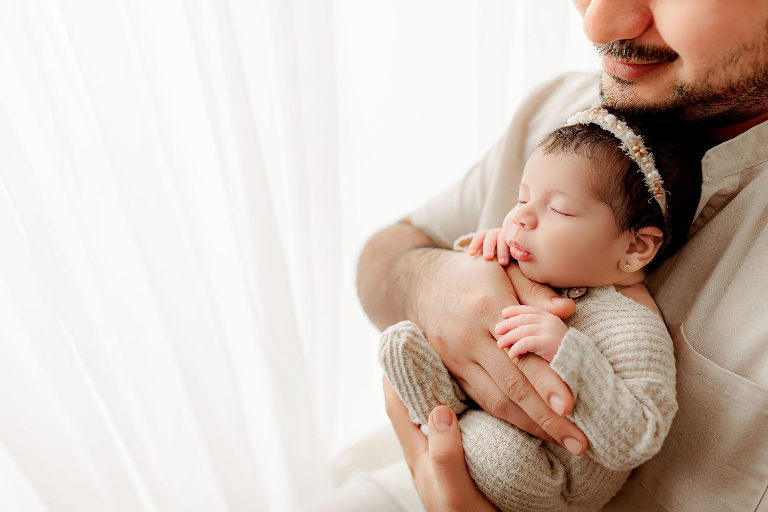 Father holds baby girl in cozy studio setting with Indianapolis Newborn Photographer