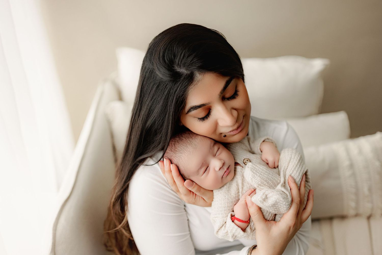 Mother holding newborn in neutrals with soft light in Indianapolis Newborn Photography Studio