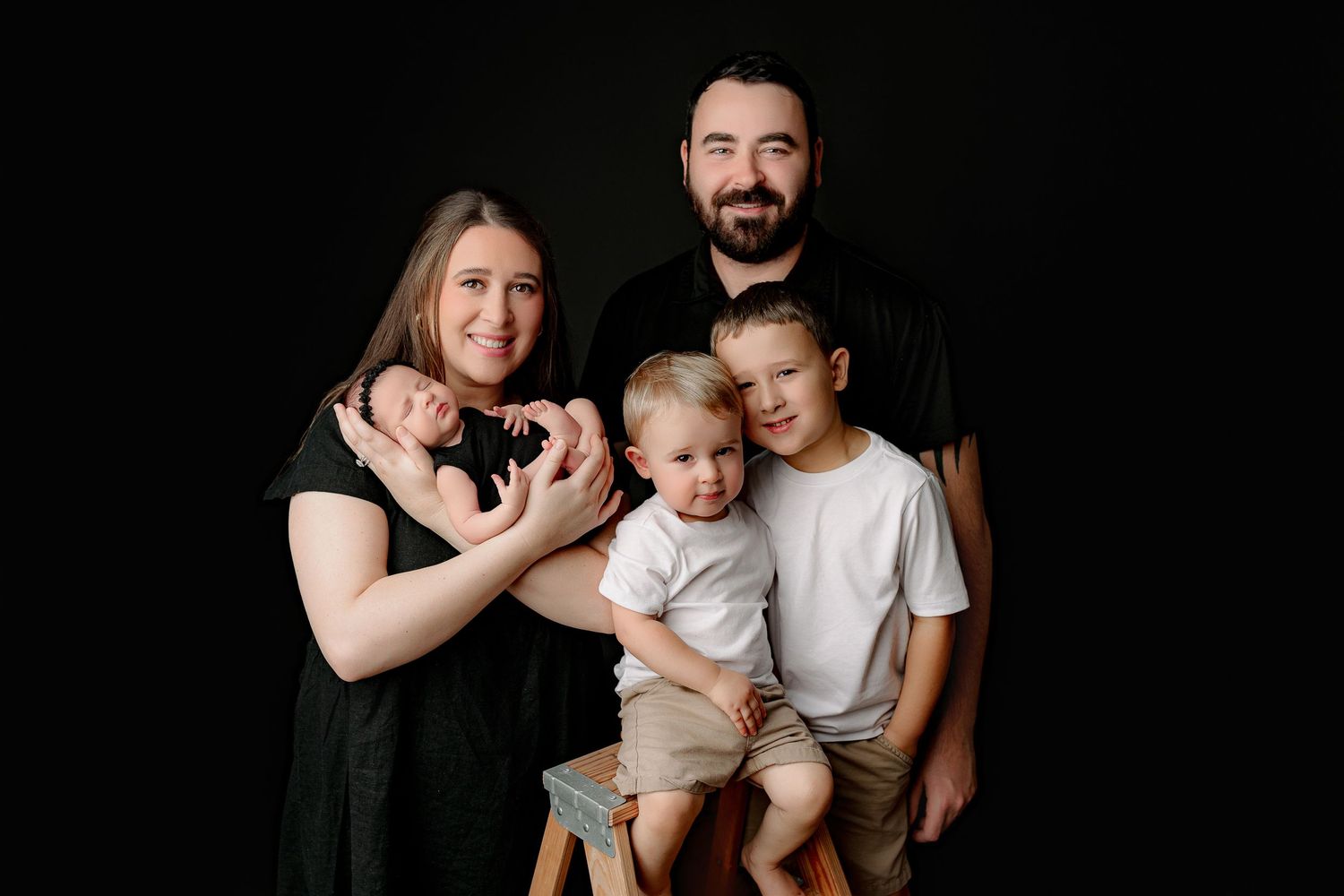Indianapolis newborn family photo with parents holding baby and siblings