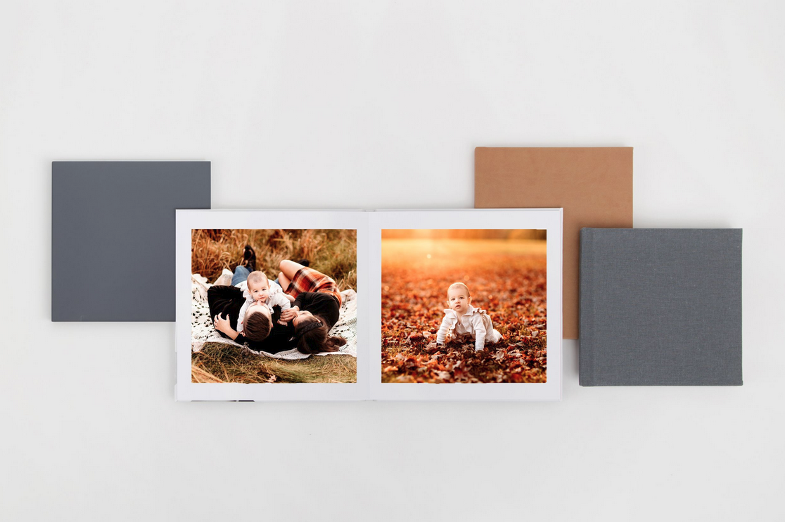 Examples of photo album covers and one album open showing a family and image of baby in leaves