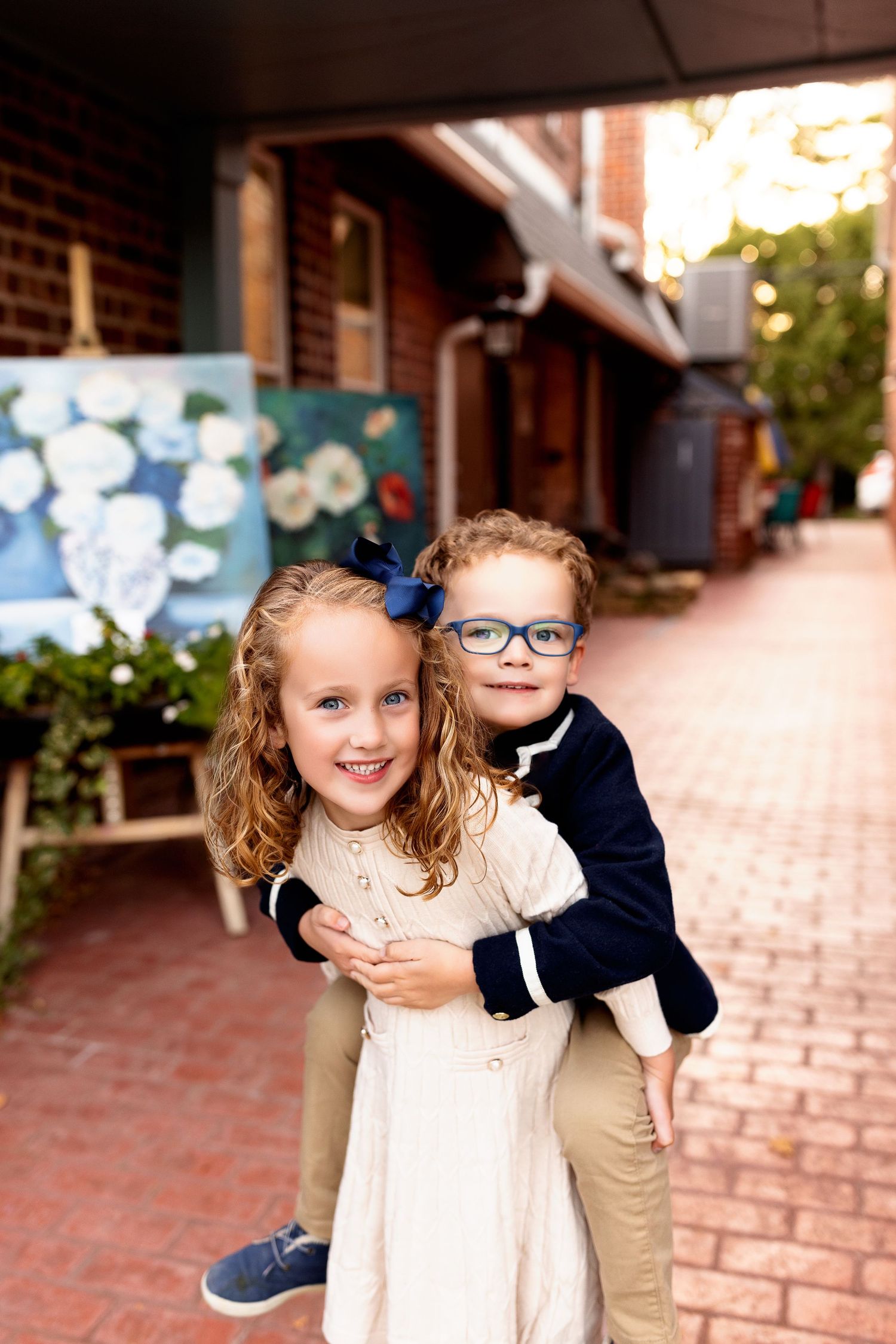 Young girl giving brother piggy back ride for family photo shoot in Zionsville Indiana