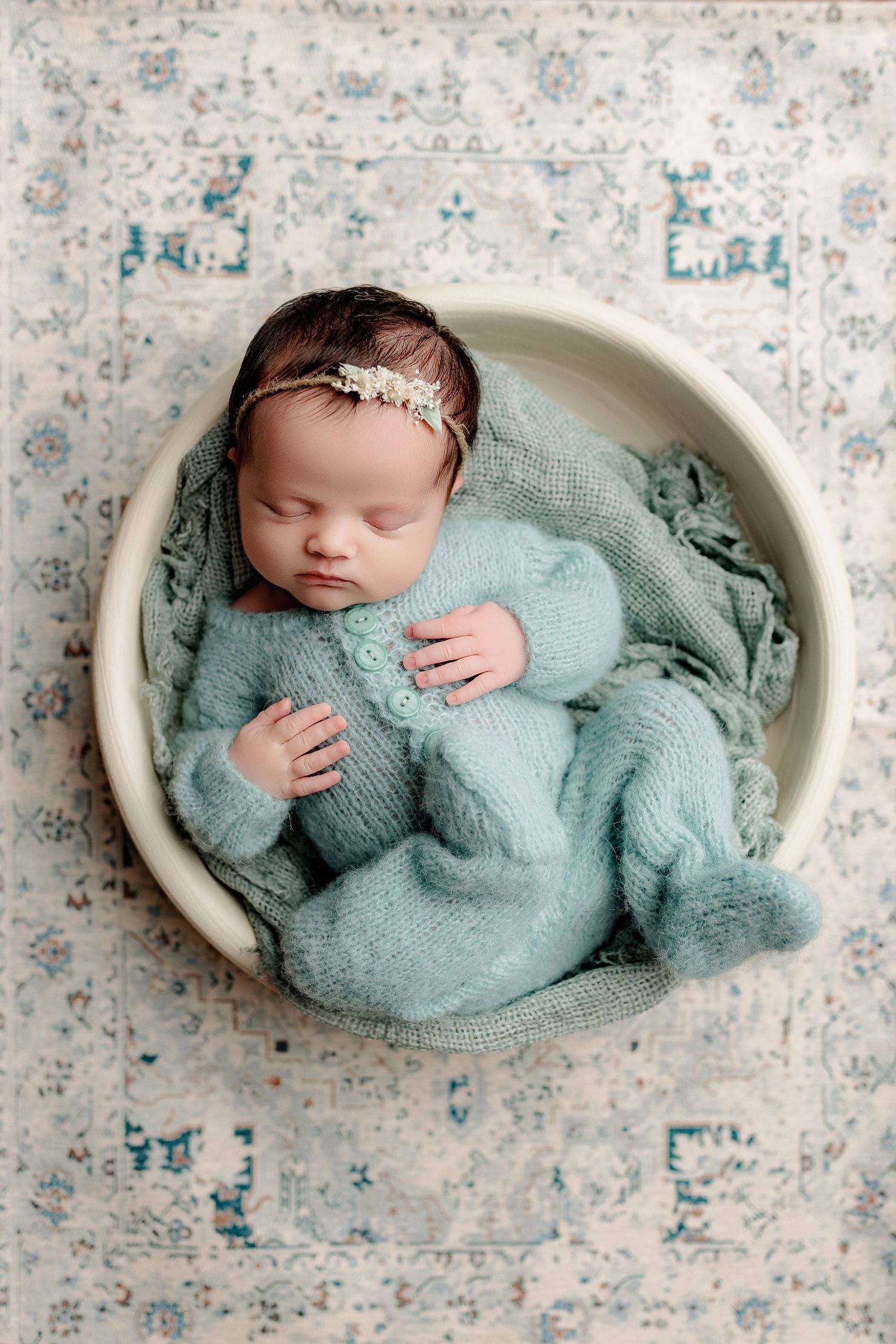 sleeping baby girl in blue knit outfit peacefully sleeping in bowl newborn photography Indianapolis Indiana