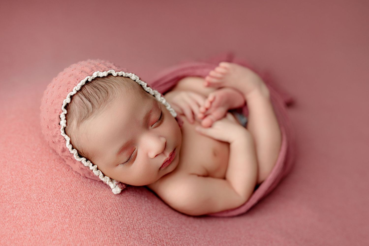 Indianapolis newborn baby girl session with pink swaddle and bonnet