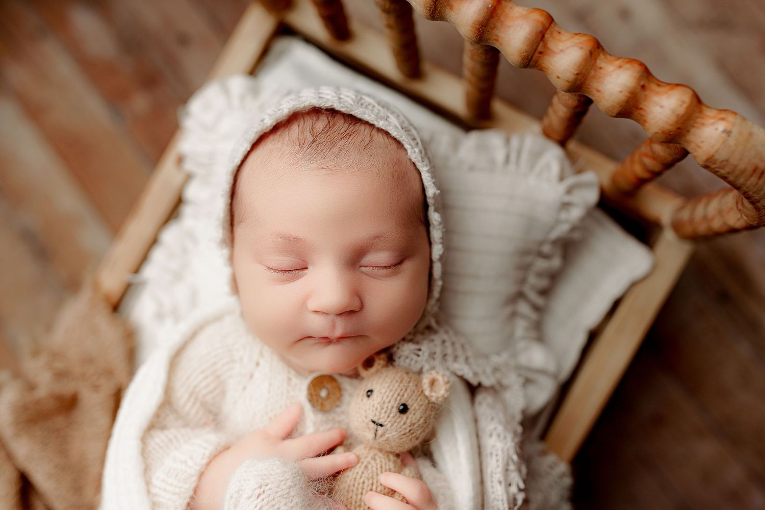 Sleeping baby posed in tiny bed with neutrals studio newborn session in Indianapolis