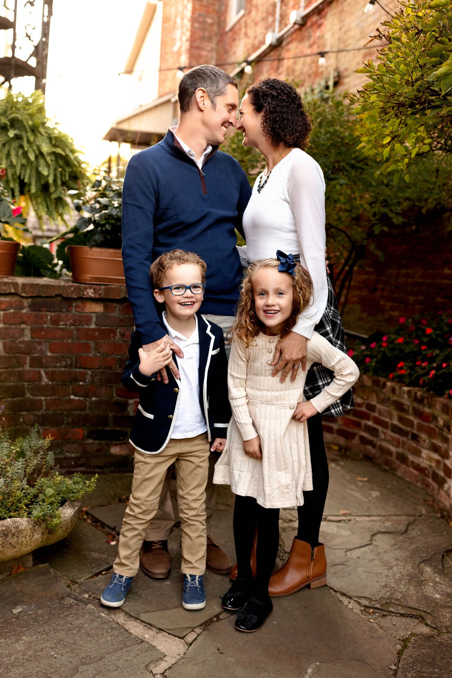 A family of four stands in a courtyard for a family portrait in Zionsville, Indiana