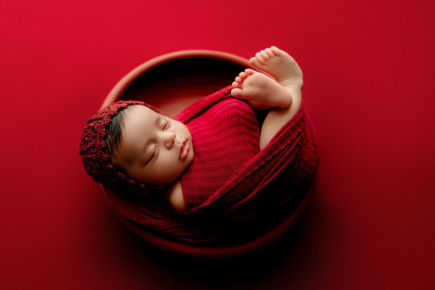 Indianapolis newborn photographer sleepy baby in wood bowl with red tones
