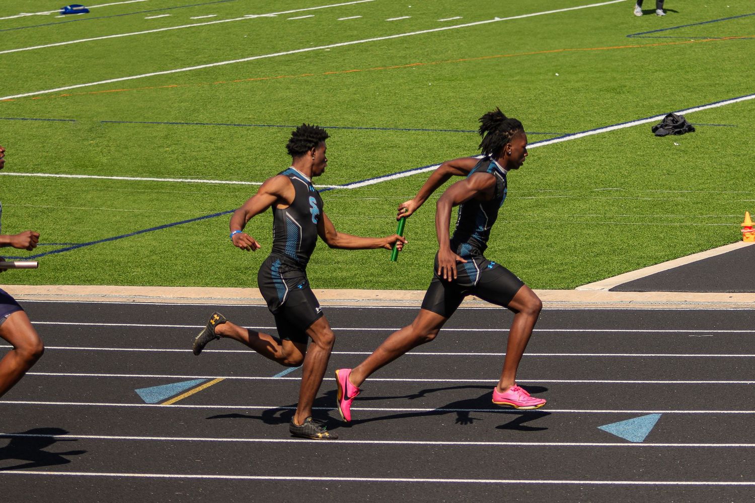 Shadow Creek High School athletes passing the baton during a relay race at the area track meet in Missouri City, TX.