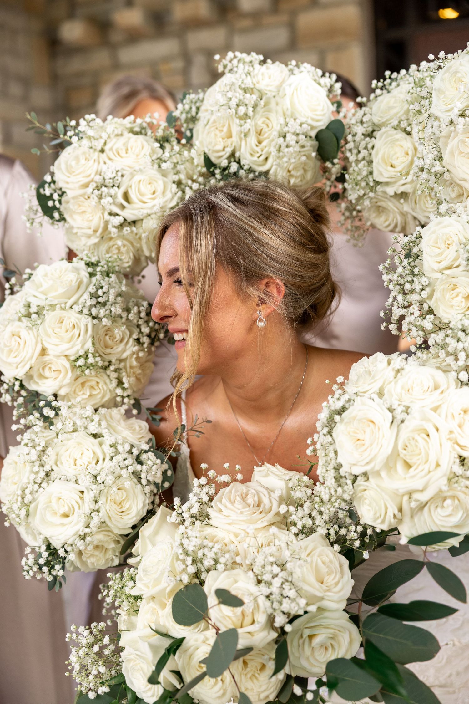 Elegant white rose and baby's breath wedding bouquets with greenery accents.