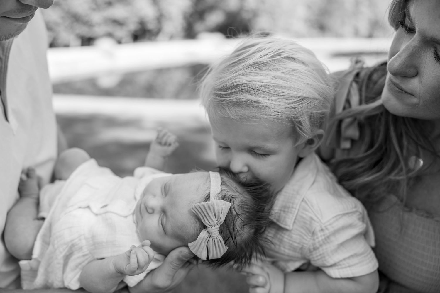 Intimate black and white portrait of parent and baby sharing a tender moment.