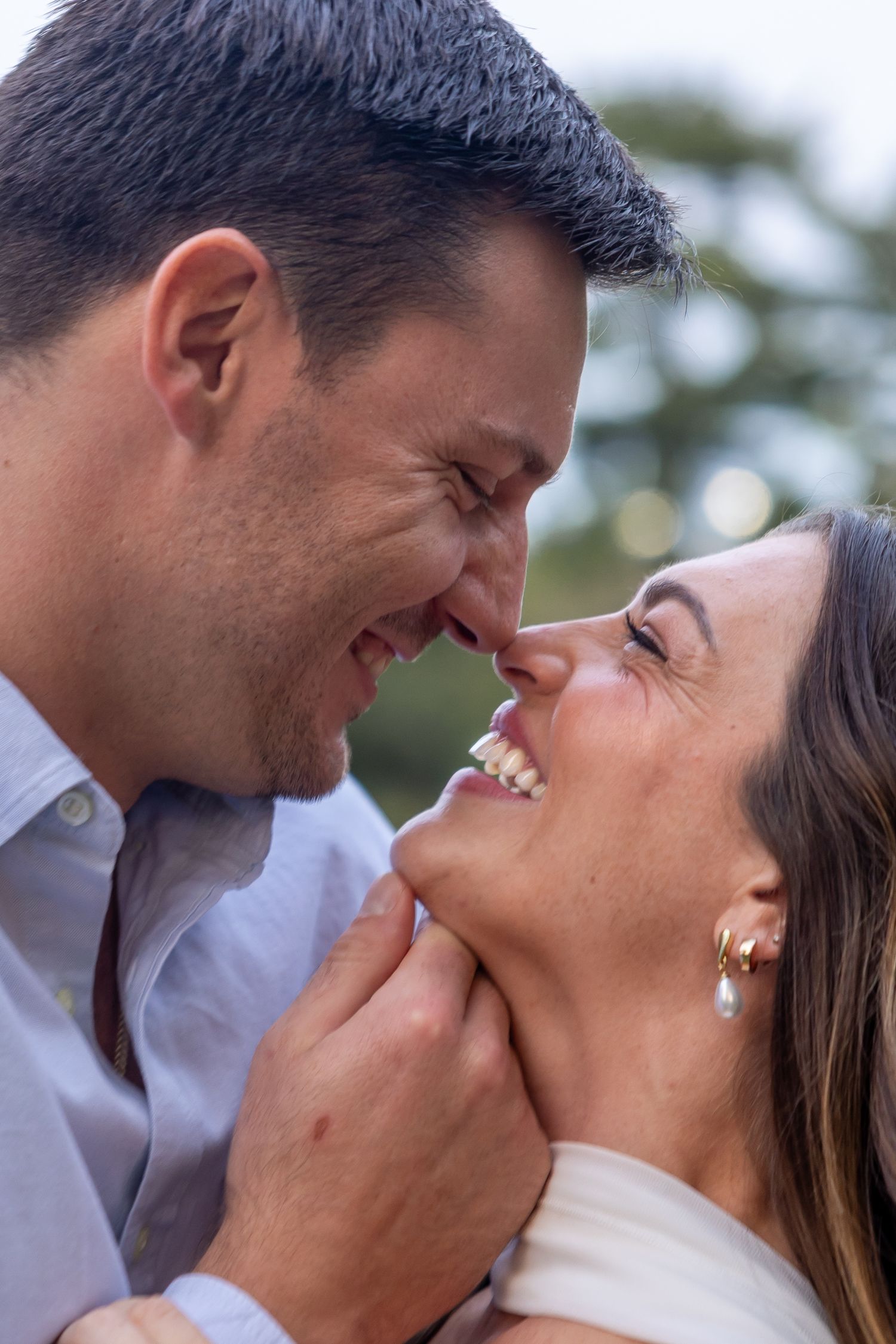 An intimate close-up moment shared between a couple during an outdoor photoshoot.