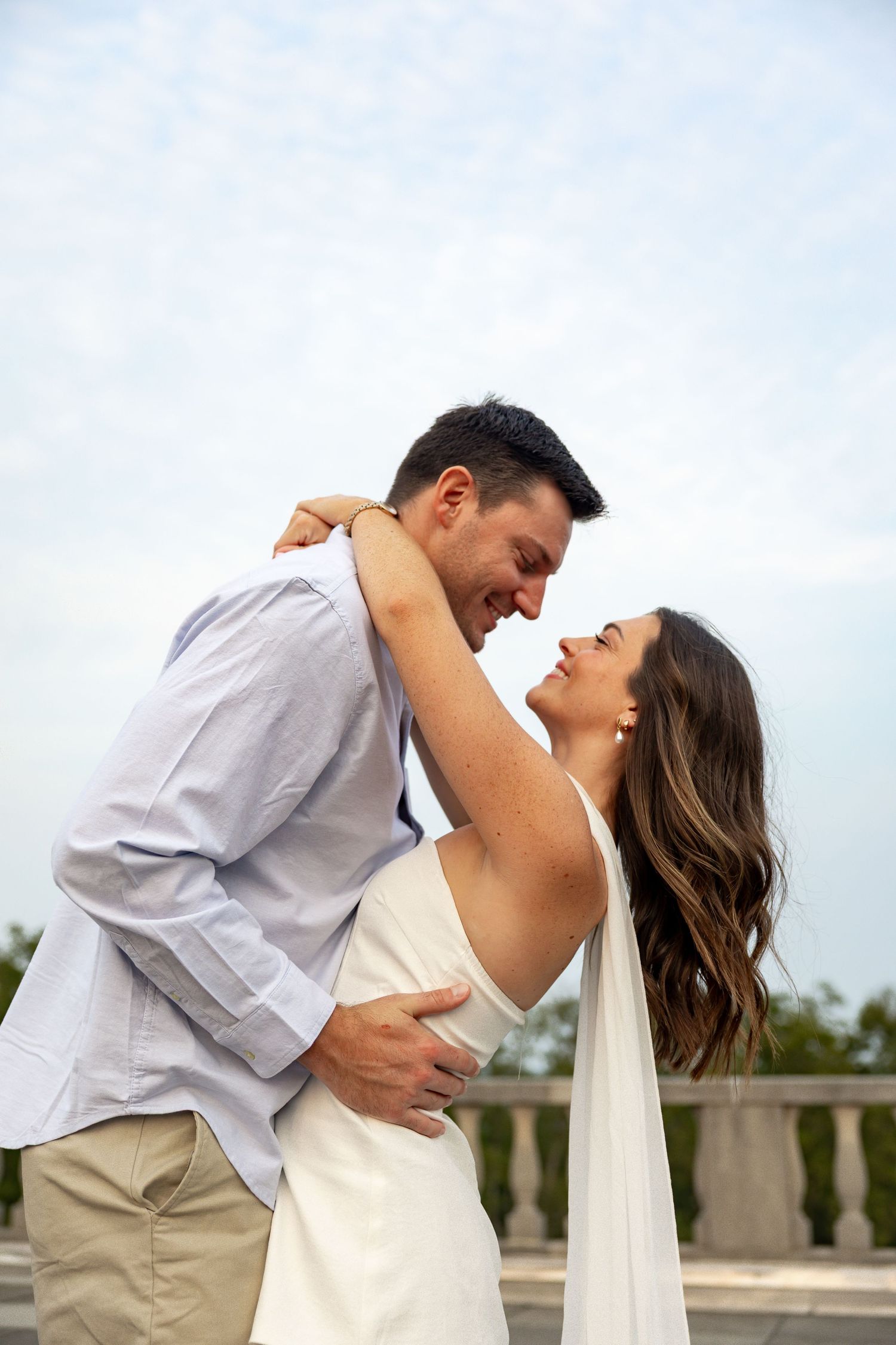 A romantic sequence showing a couple in white clothing embracing outdoors.