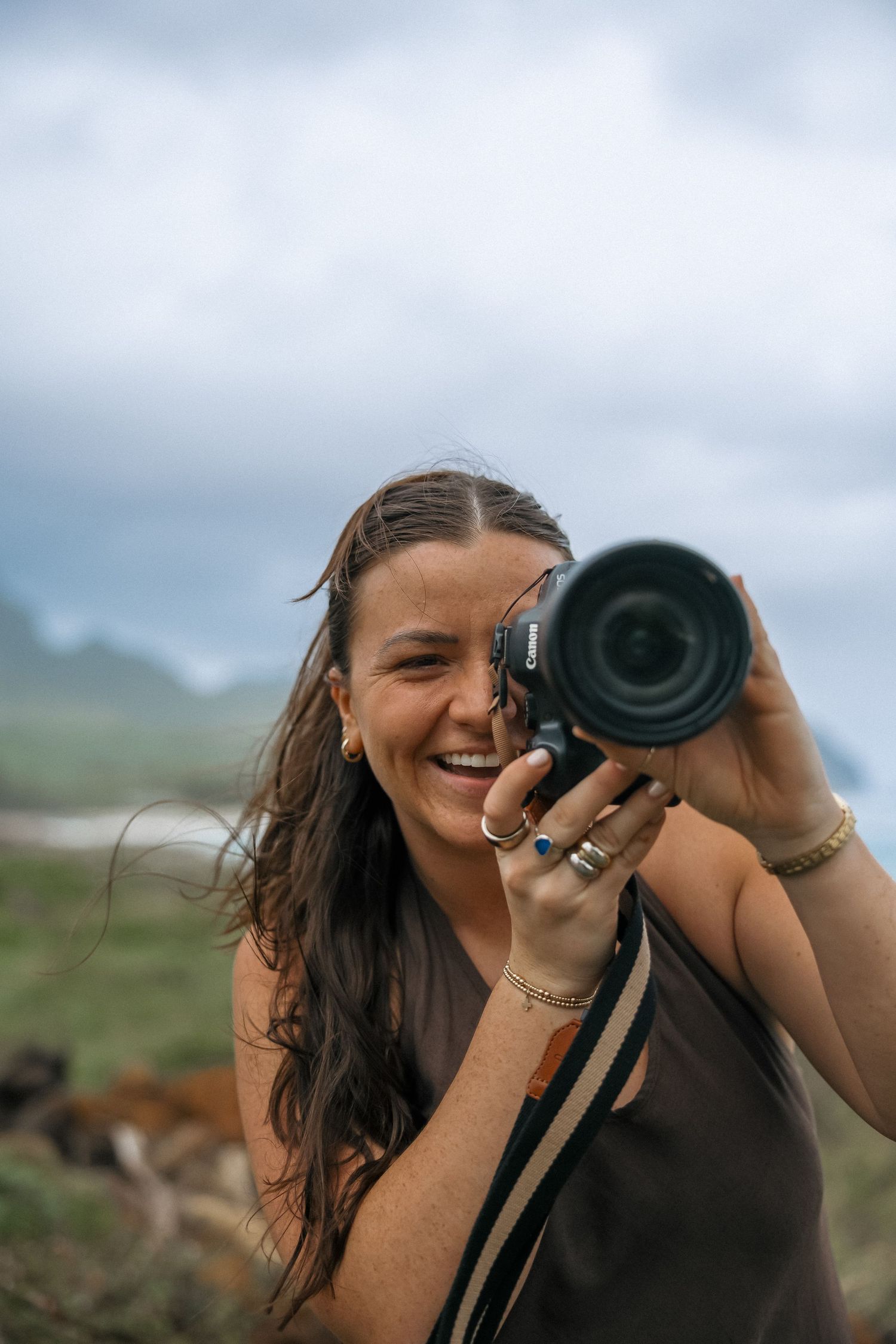 Photographer smiles while taking pictures with professional camera equipment.