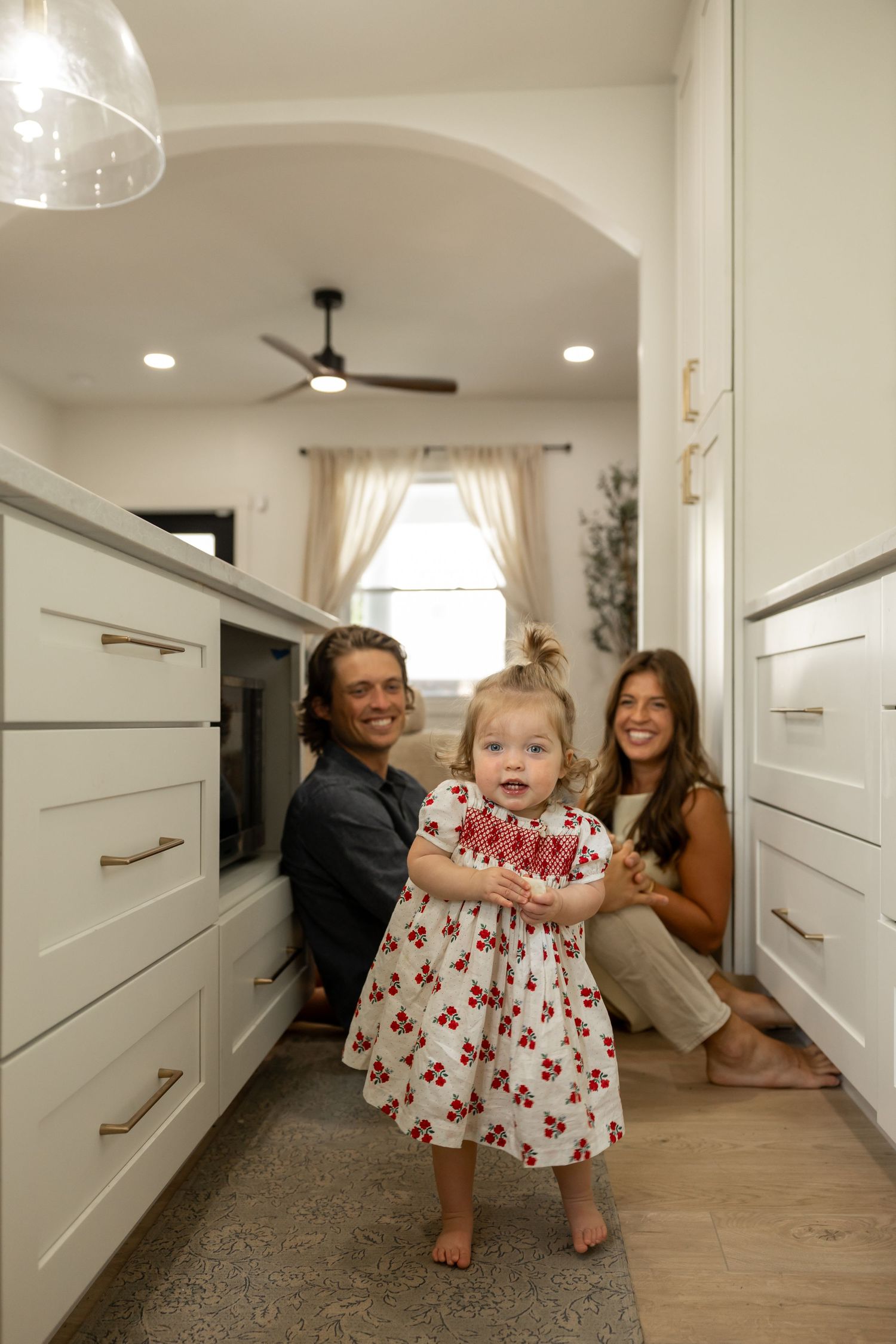 A playful sequence of photos showing movement and laughter in a bright hallway with white doors.