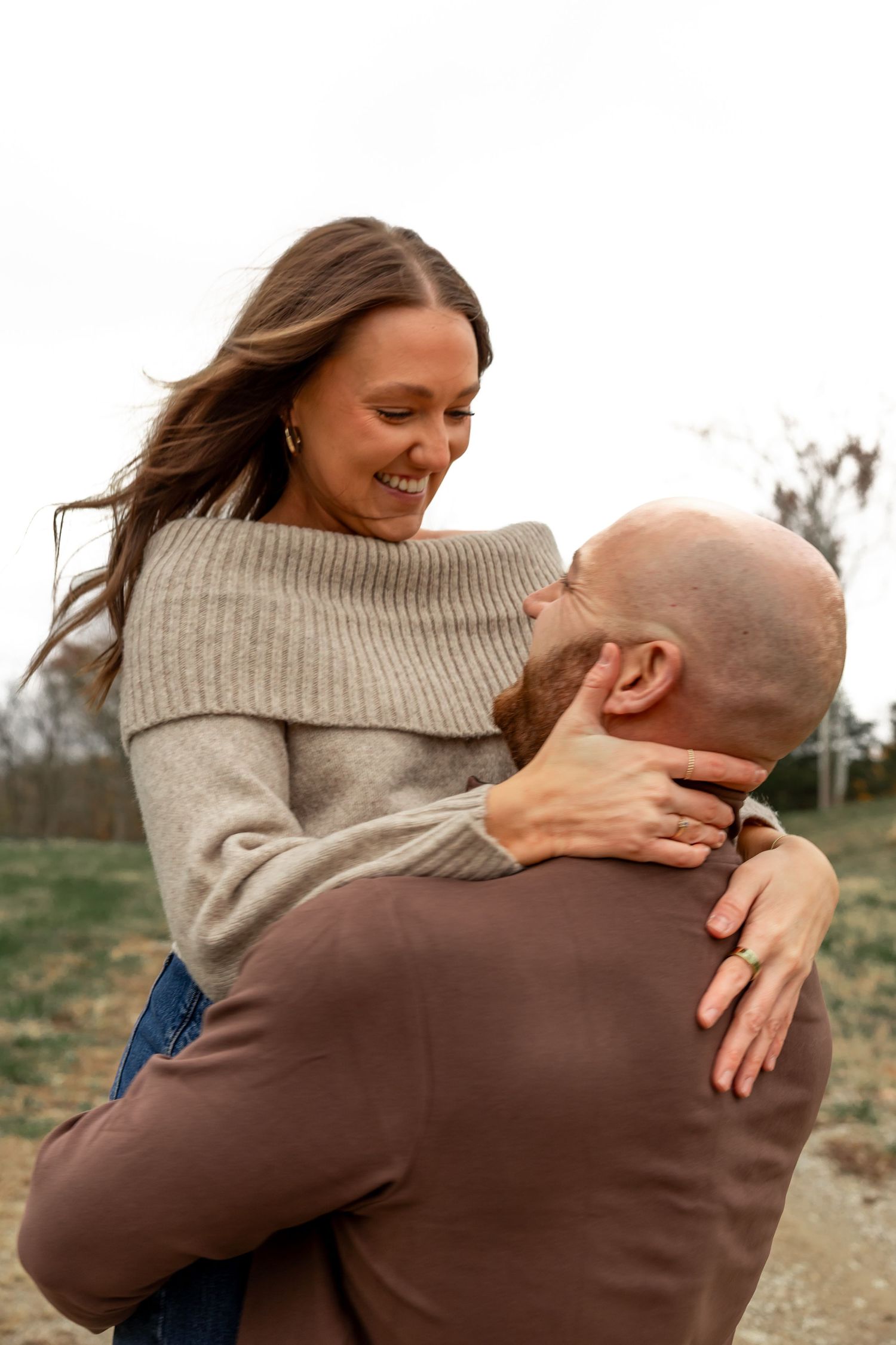 Couple sharing an intimate moment outdoors in casual sweaters.