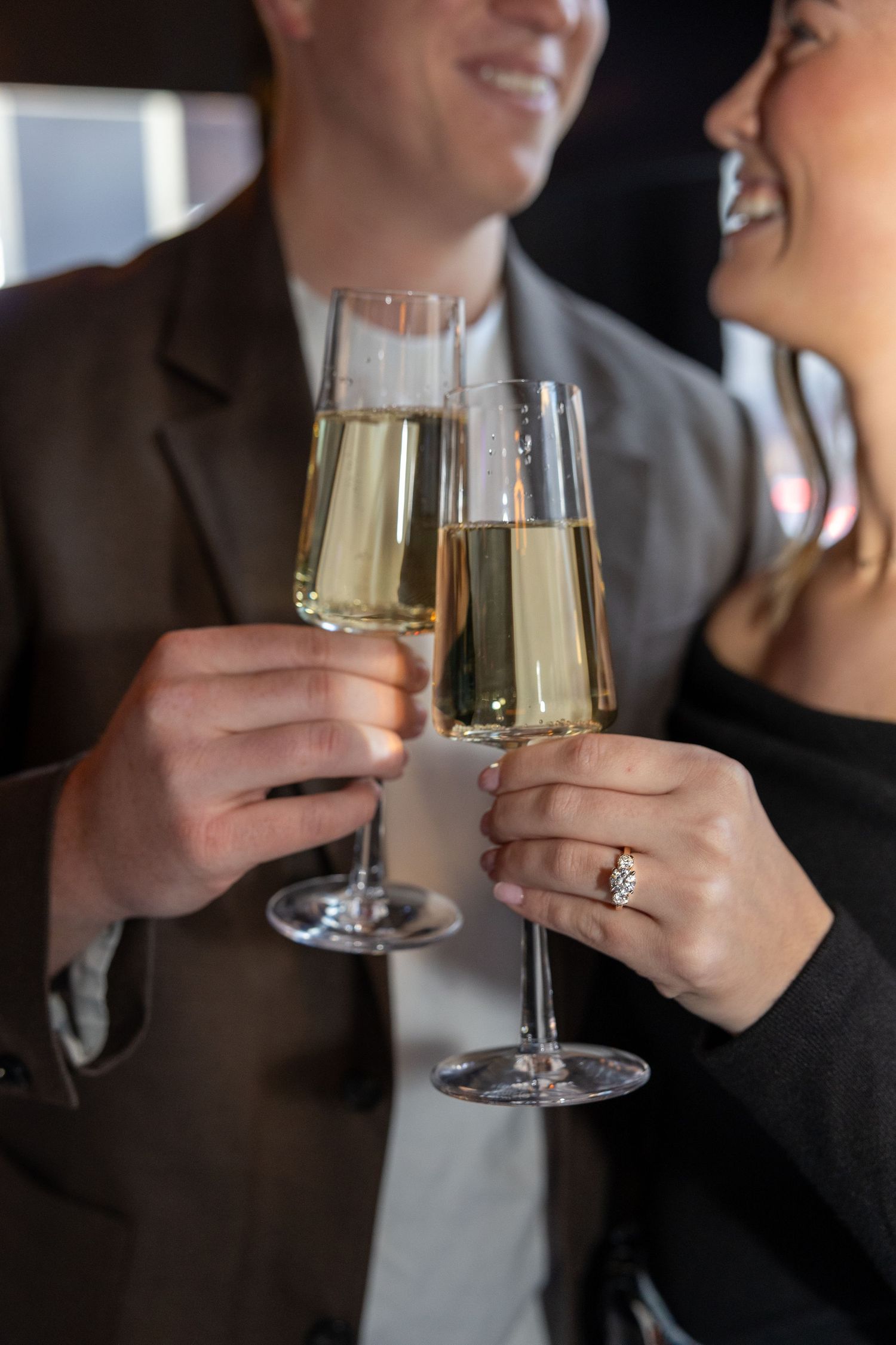 Two people toasting with champagne glasses in formal attire during a celebration.