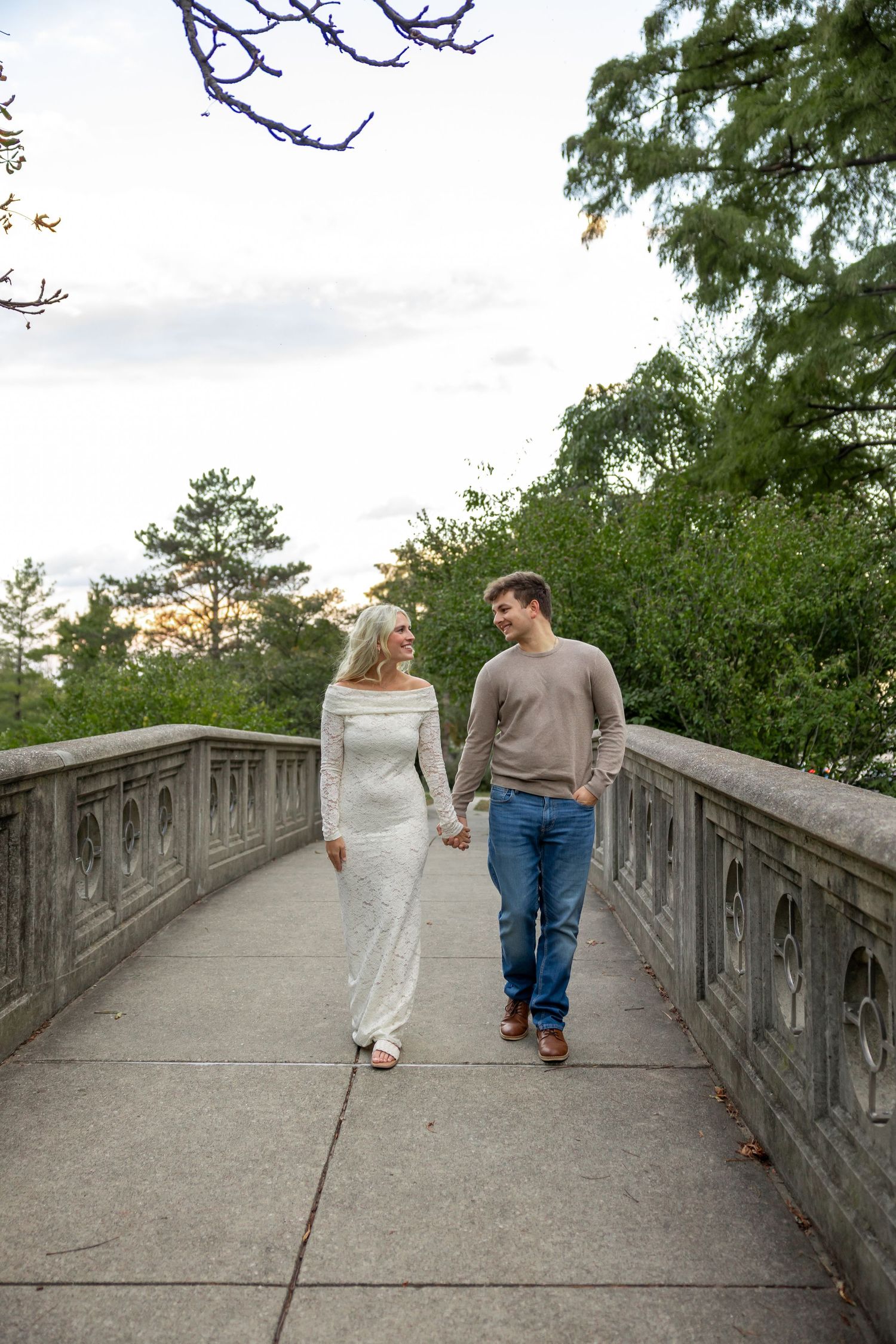 Couple walking together on stone bridge pathway.
