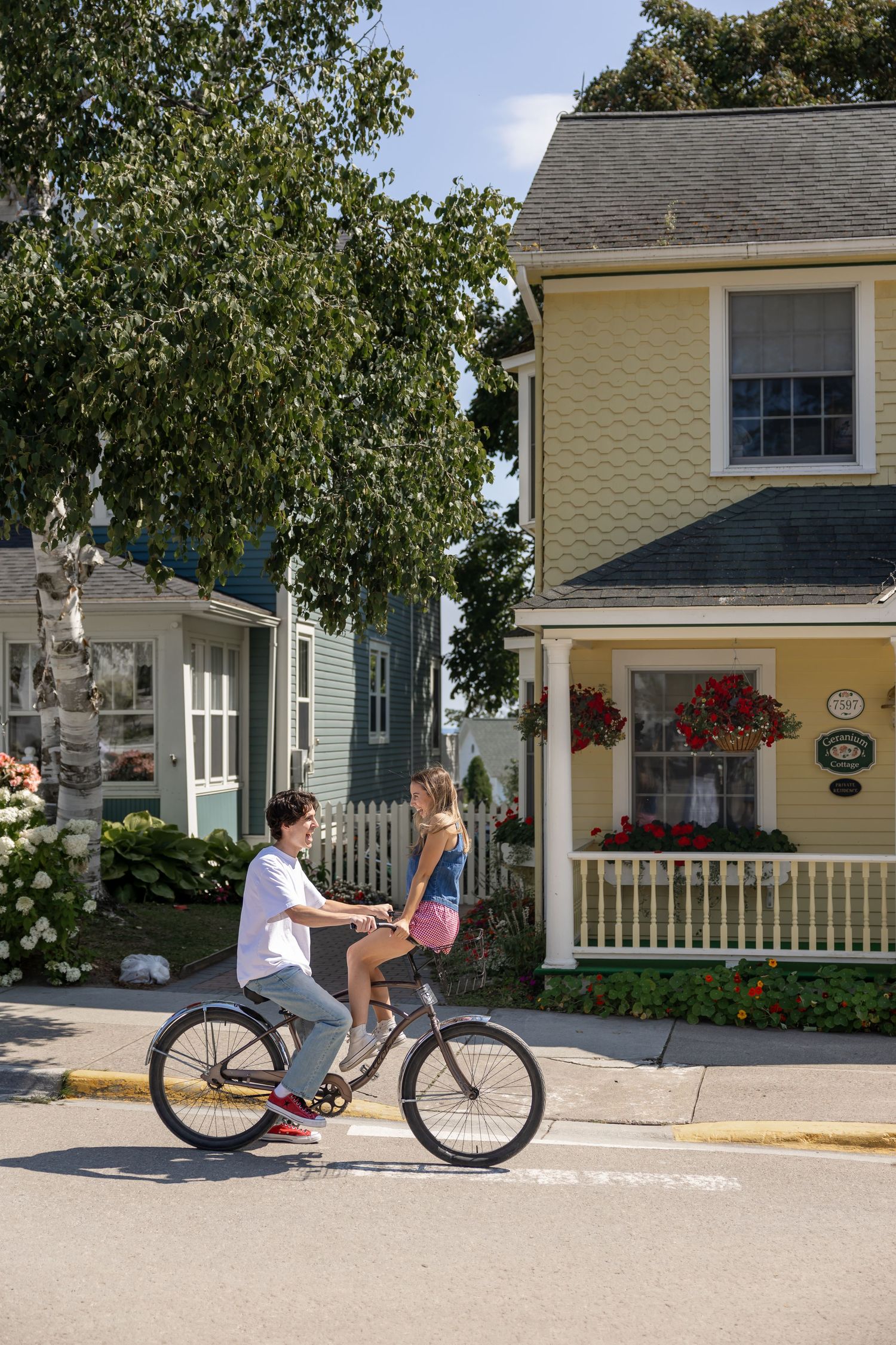 Charming yellow cottage with white trim and bicycle parked outside.