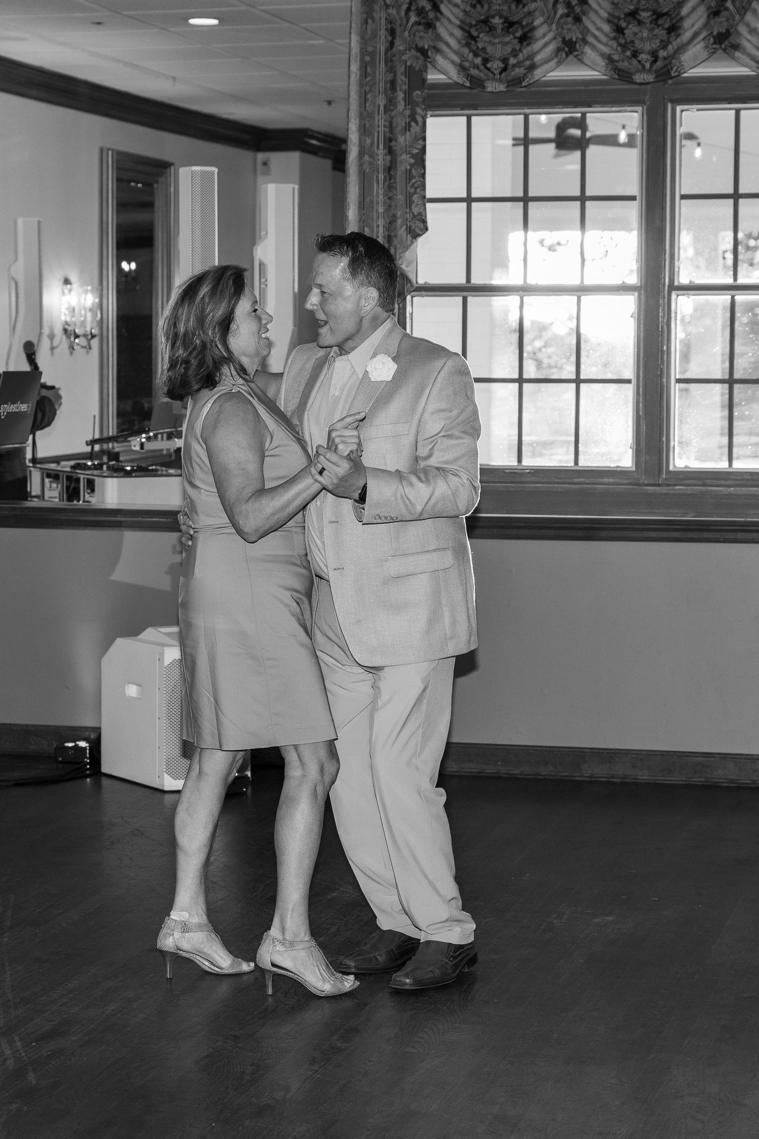 Black and white photo of couples dancing in a large indoor space.
