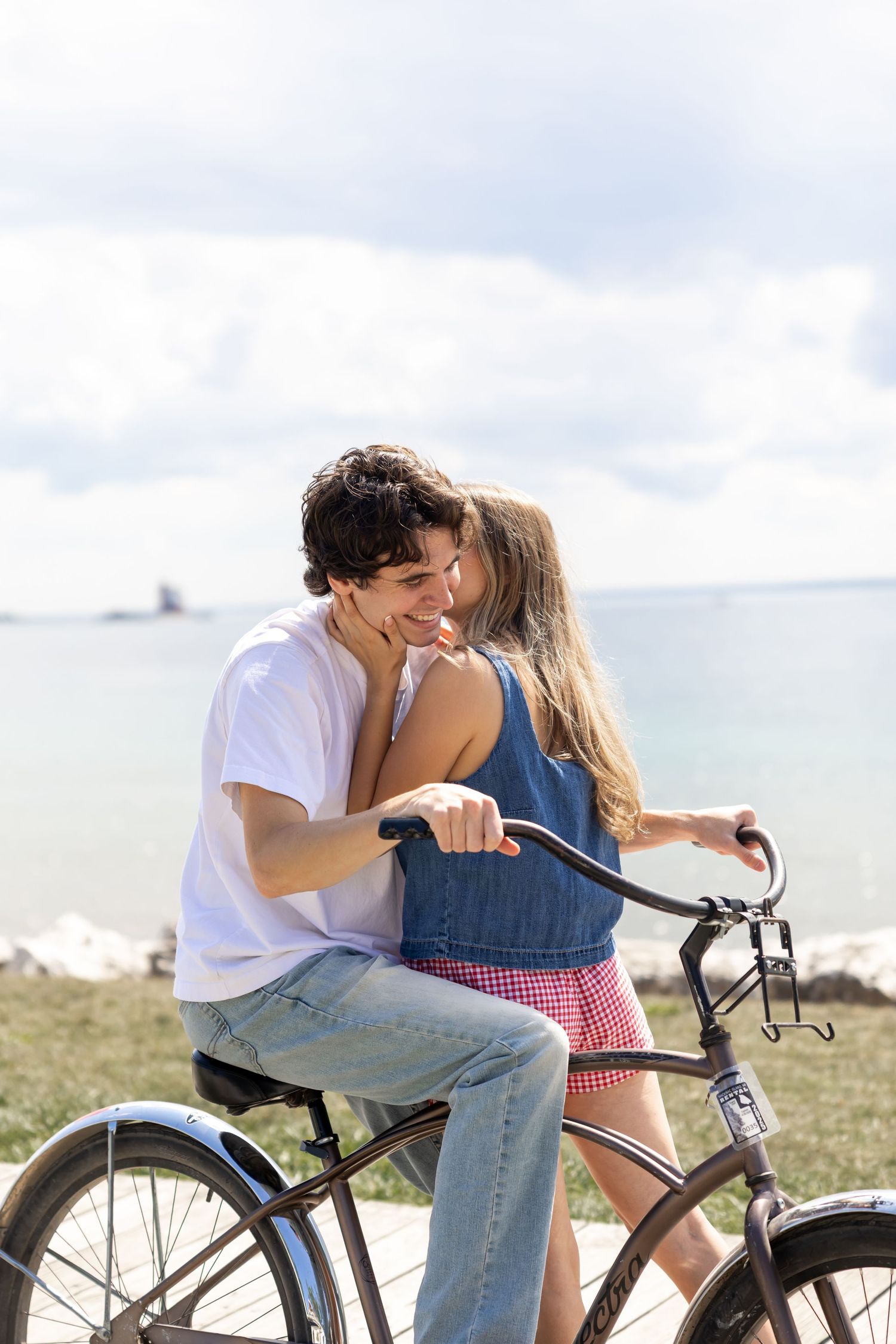 Couple sharing a romantic moment with a bicycle at the beach.