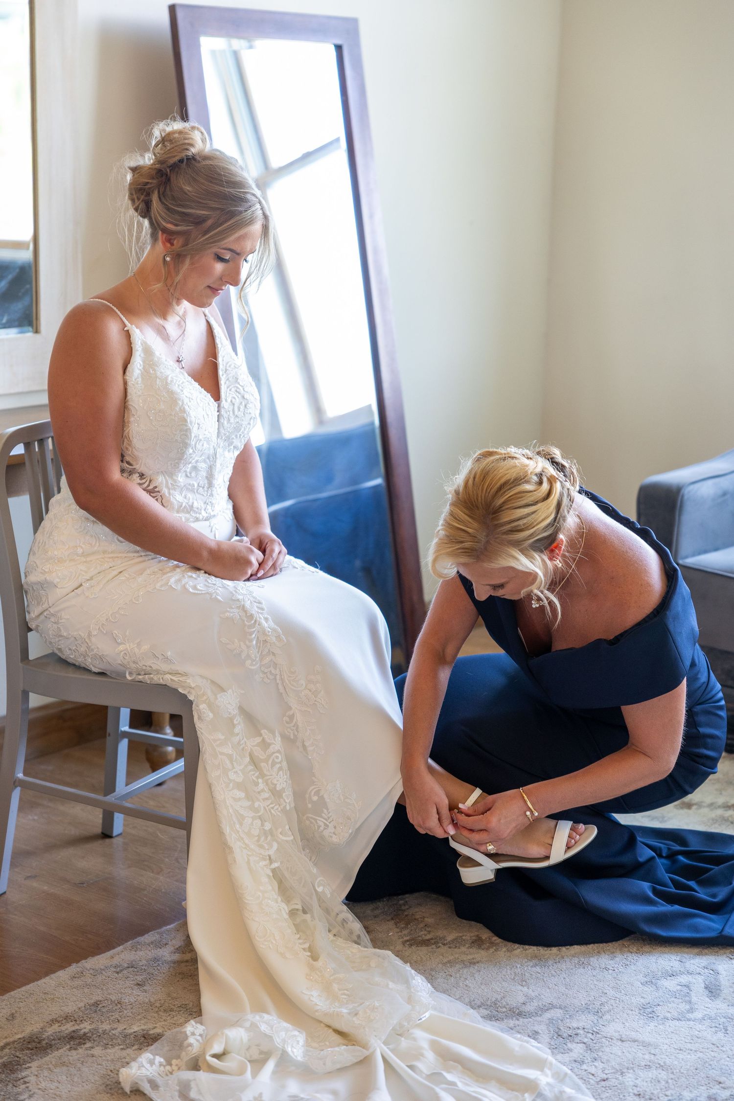 Final wedding dress preparations being made indoors before ceremony.