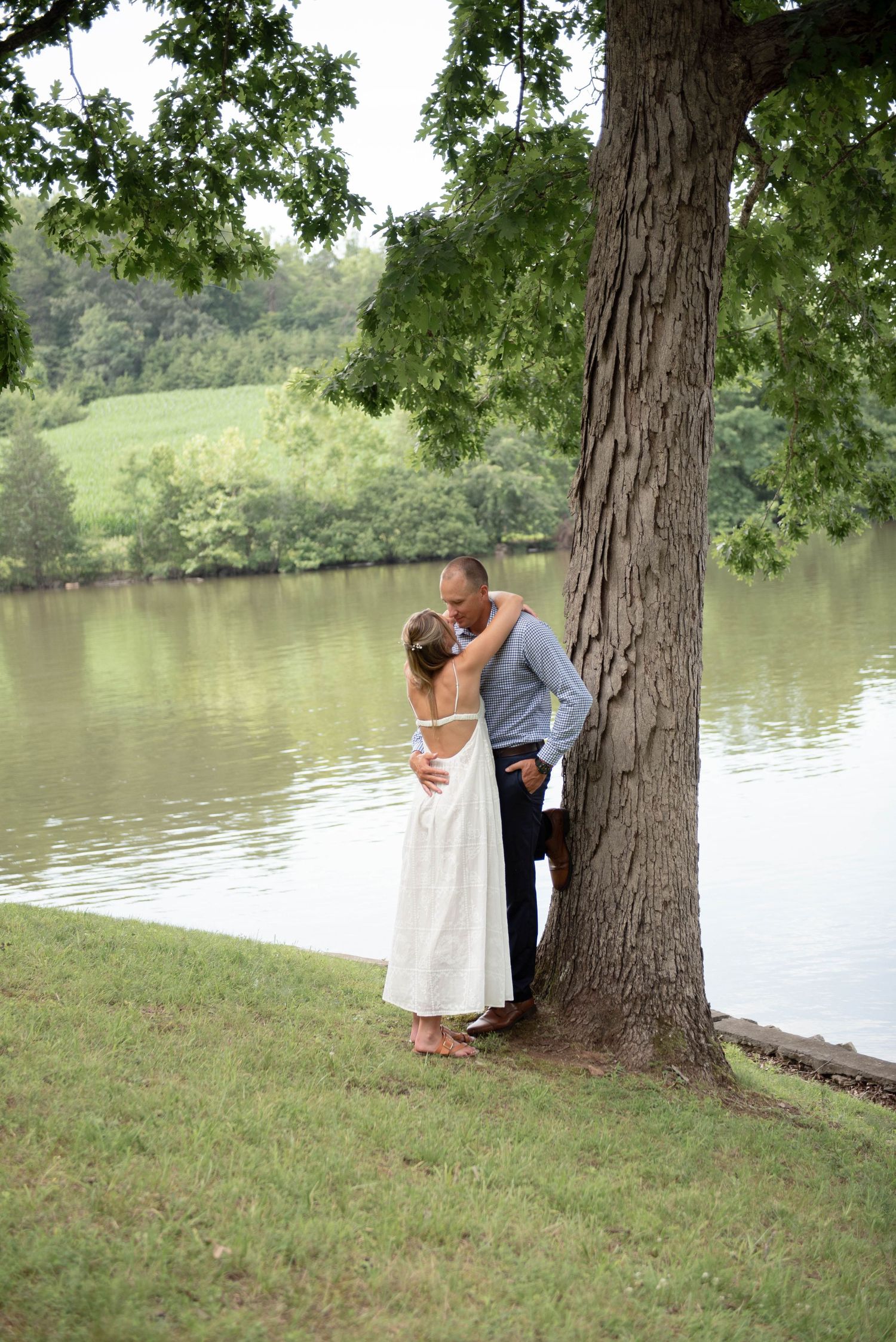 bride and groom leaning on tree