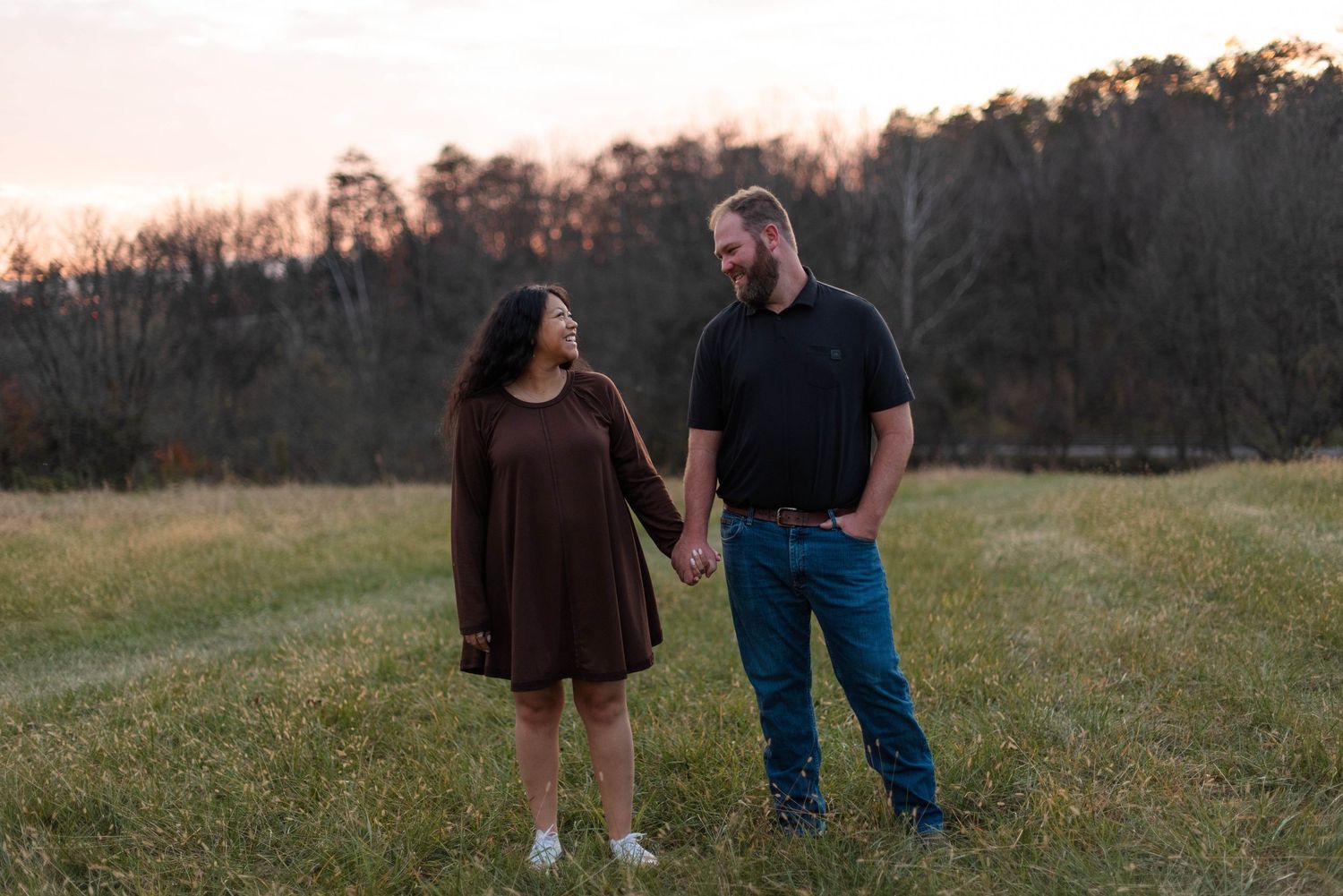 Couple holding hands in field during lifestyle portrait session