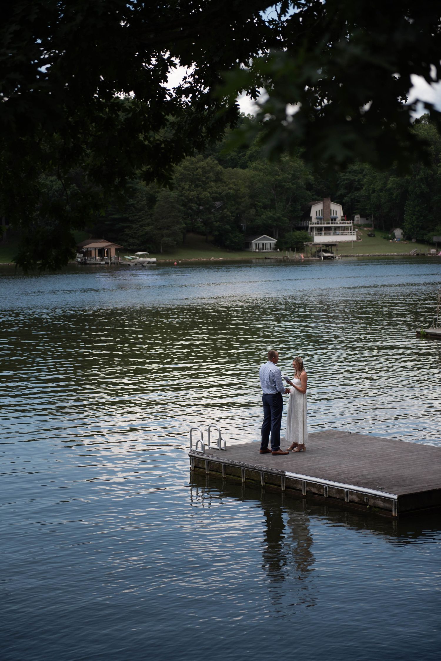 Couple reading vows on dock during wedding