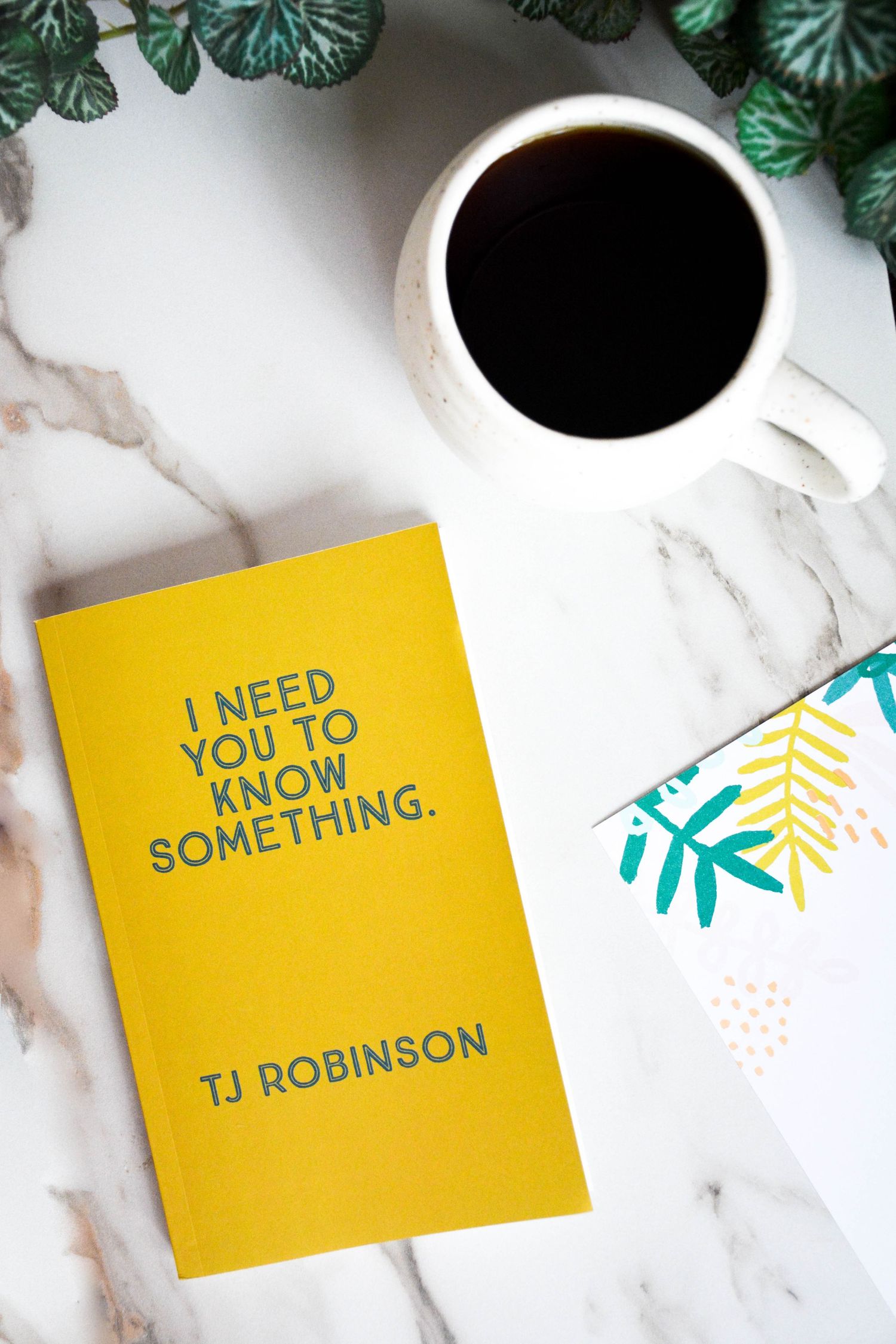 Flat lay shot of a yellow book and mug of coffee