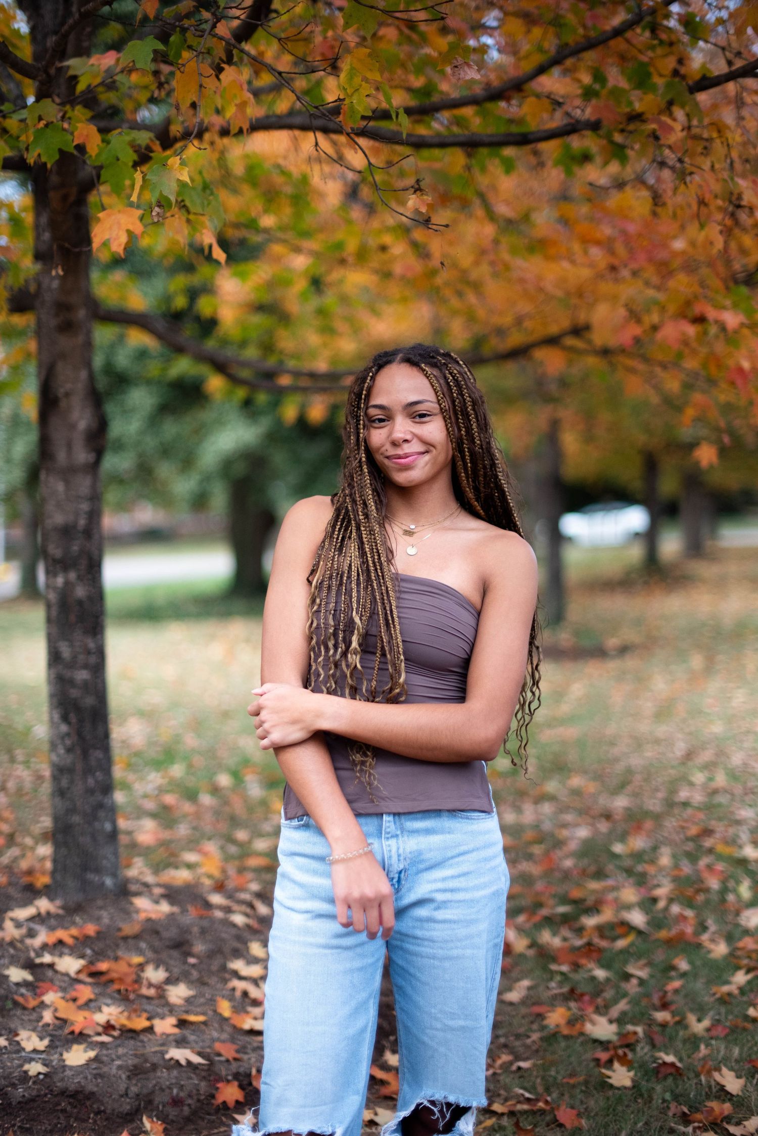 Portrait session of a young woman with fall colors and trees