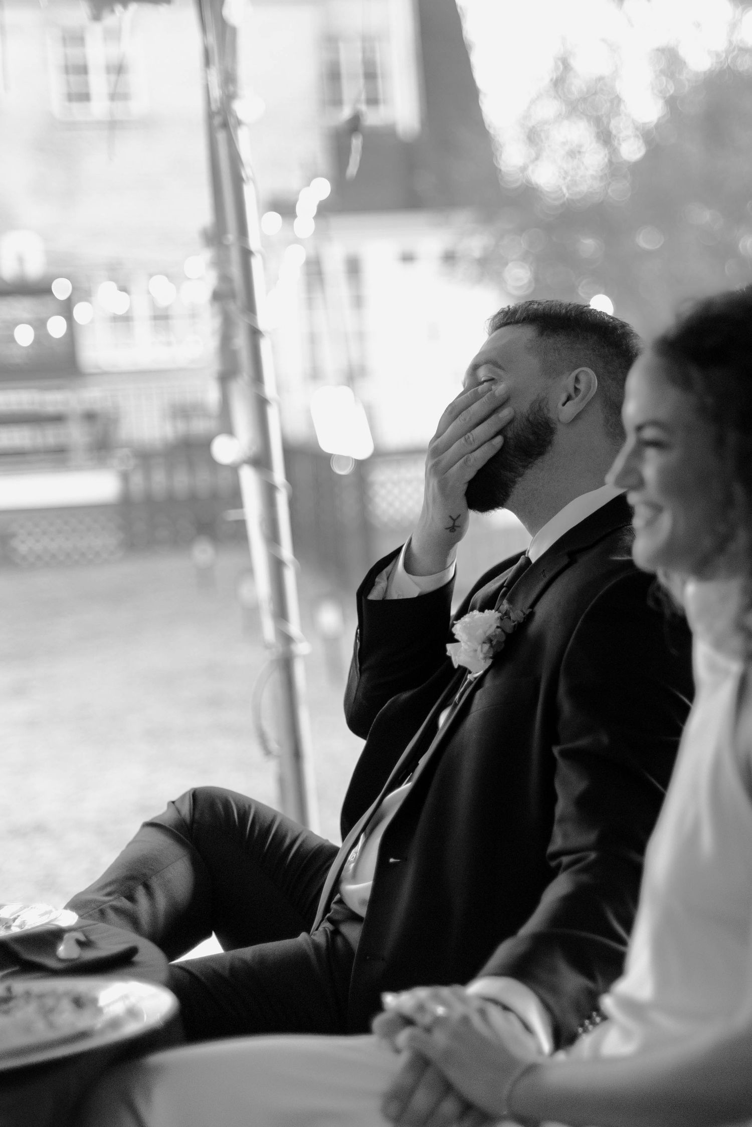 Groom laughing during wedding reception speeches