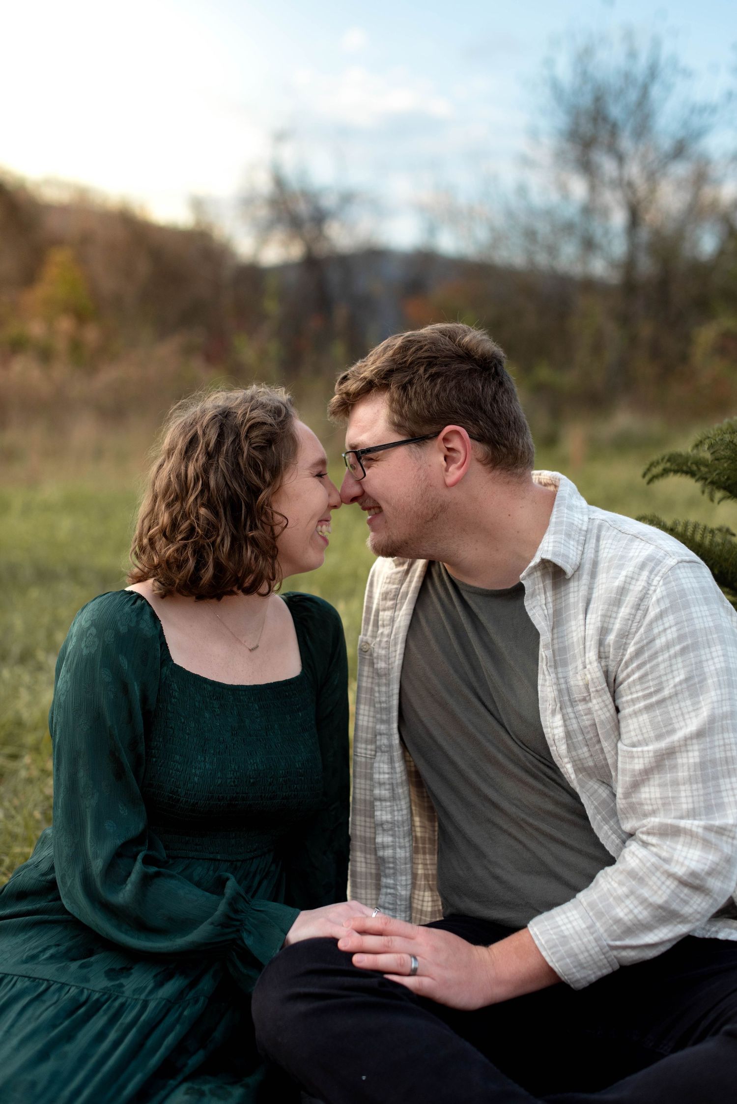 Couple nose-to-nose in field with mountain view