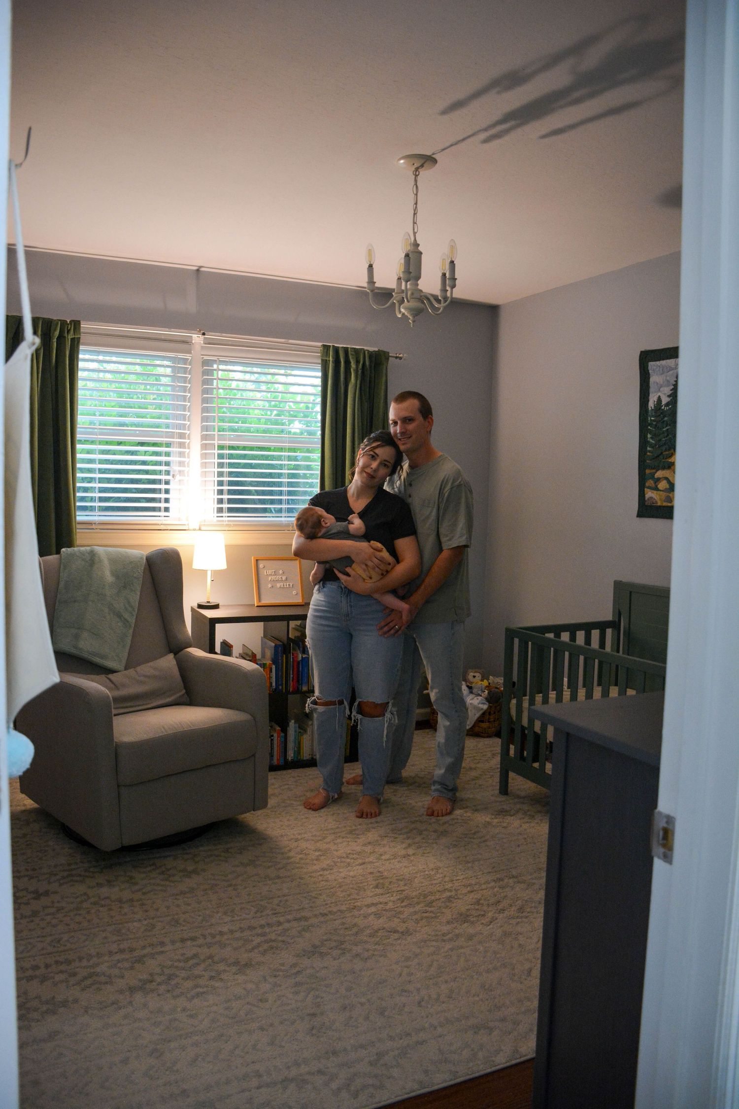 Family standing in nursery holding baby