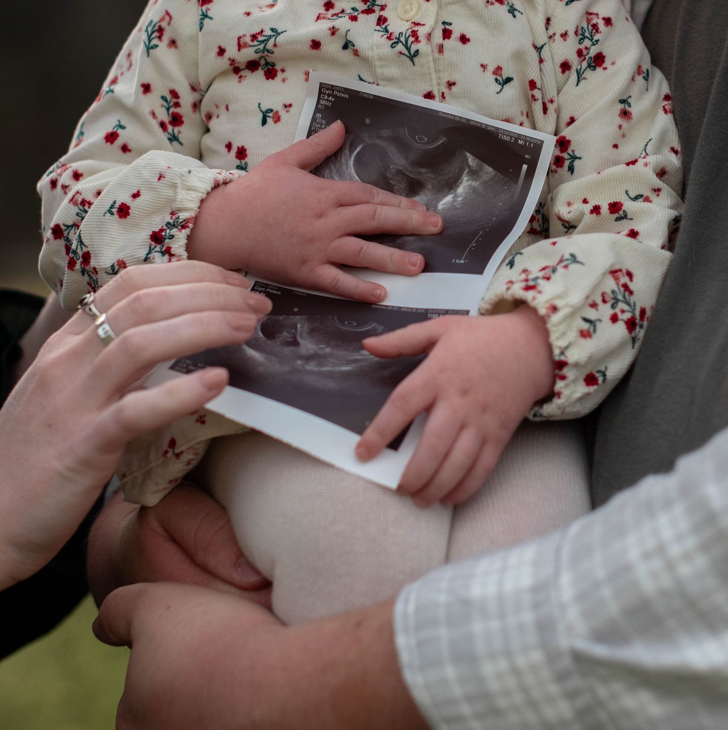 Parents holding baby while baby holds ultrasound close-up