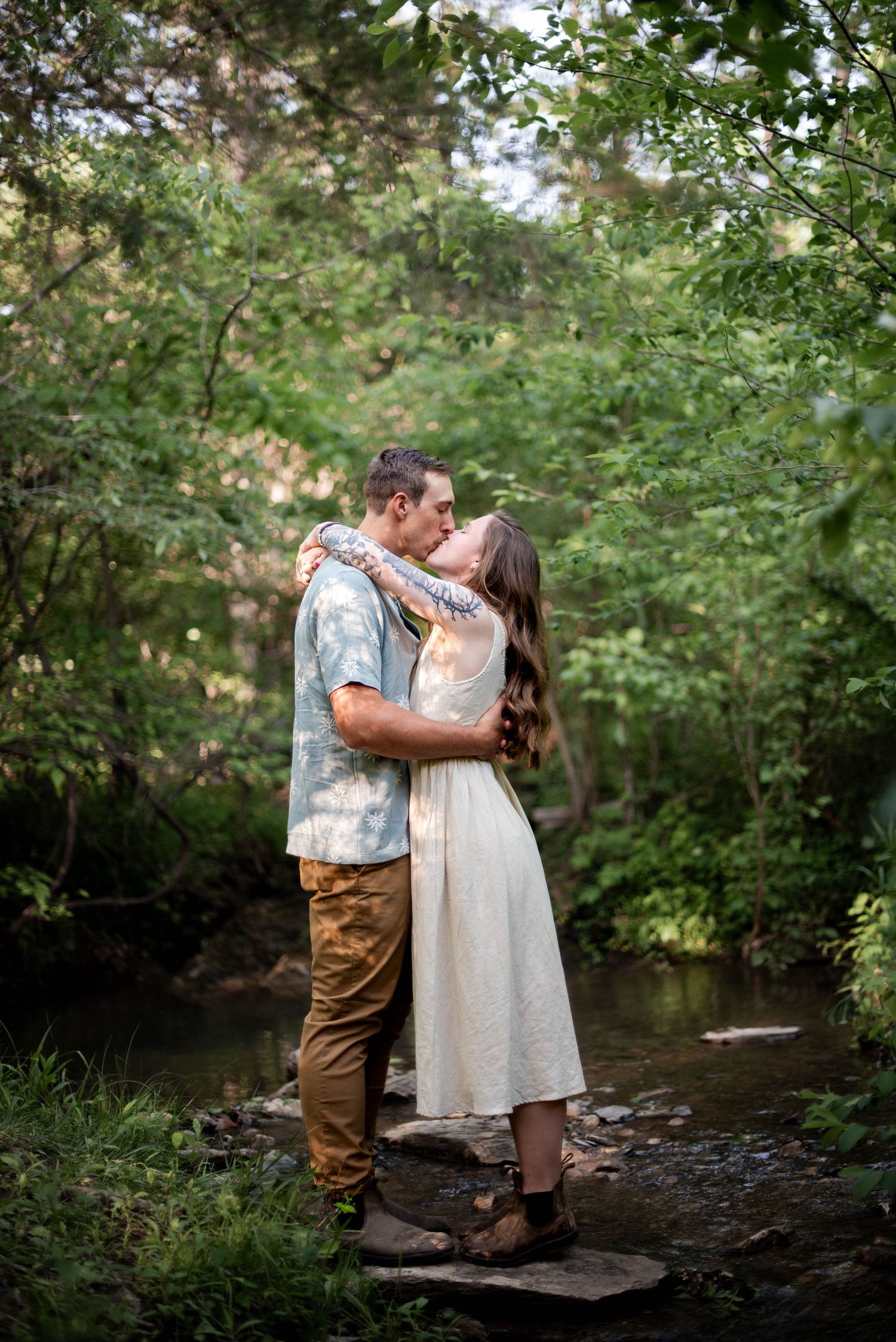 Couple standing on a rock in the creek kissing