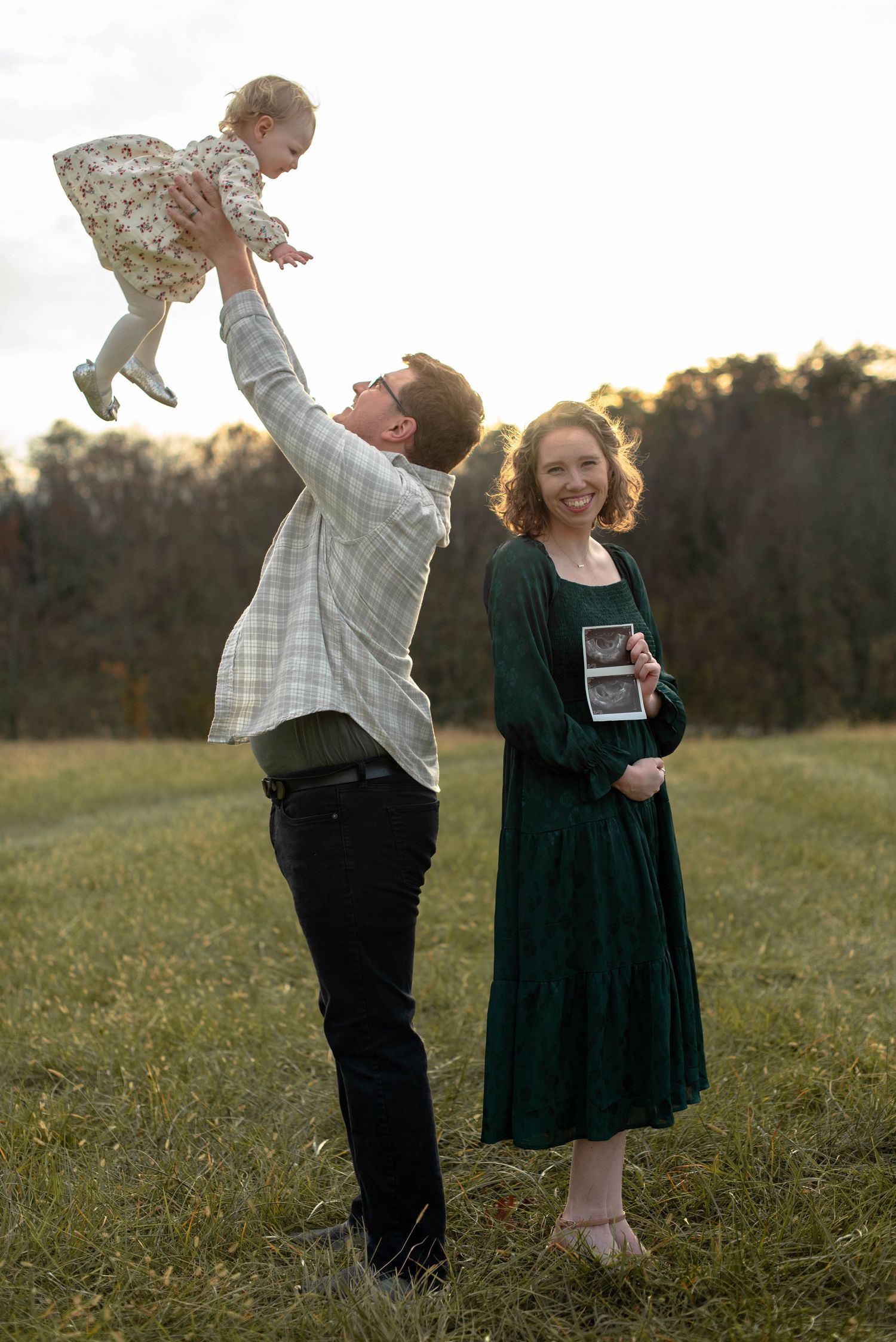 Parents with their child announcing pregnancy during portrait session
