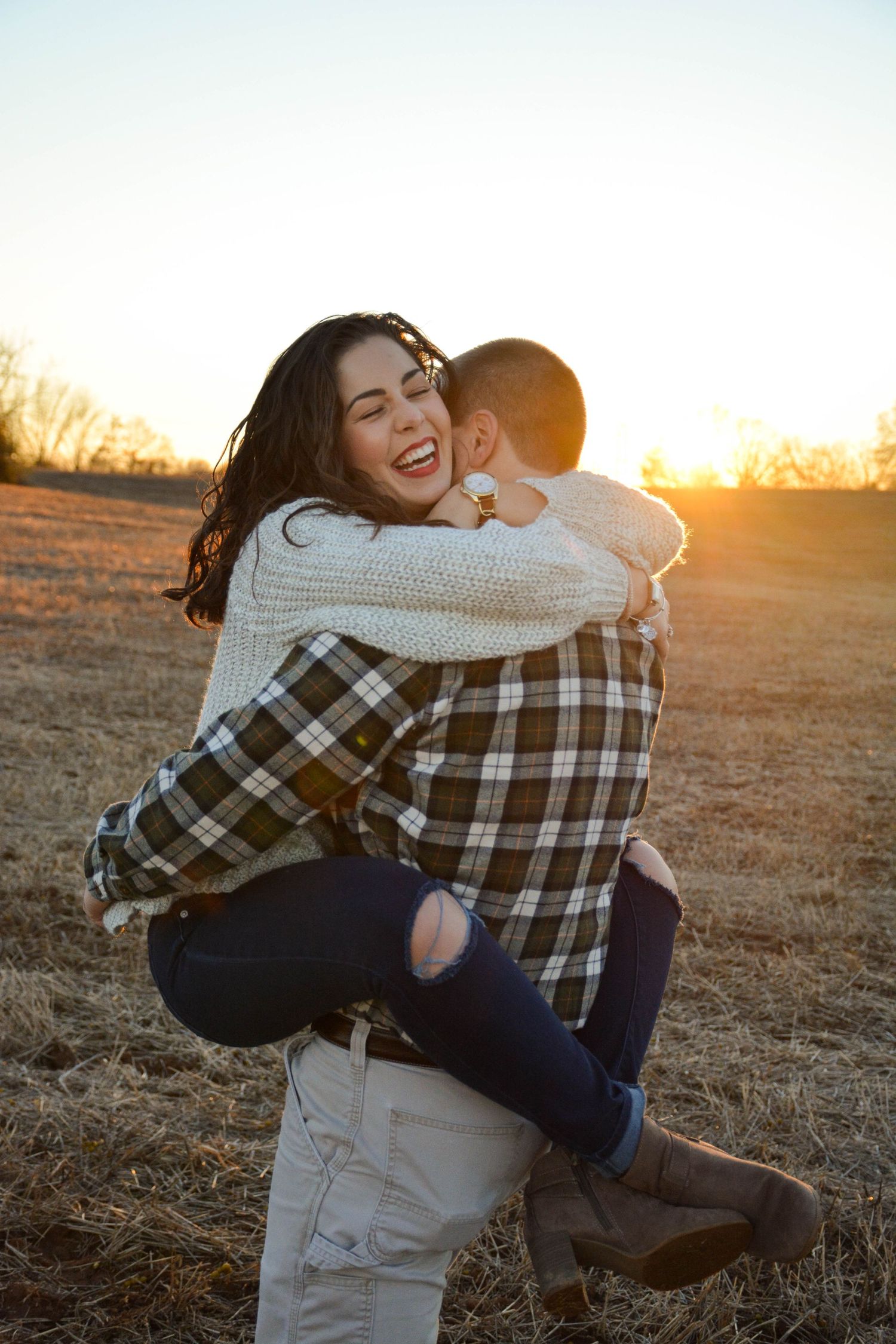 Woman with legs around man's waist, very excited, holding onto his neck after proposal.