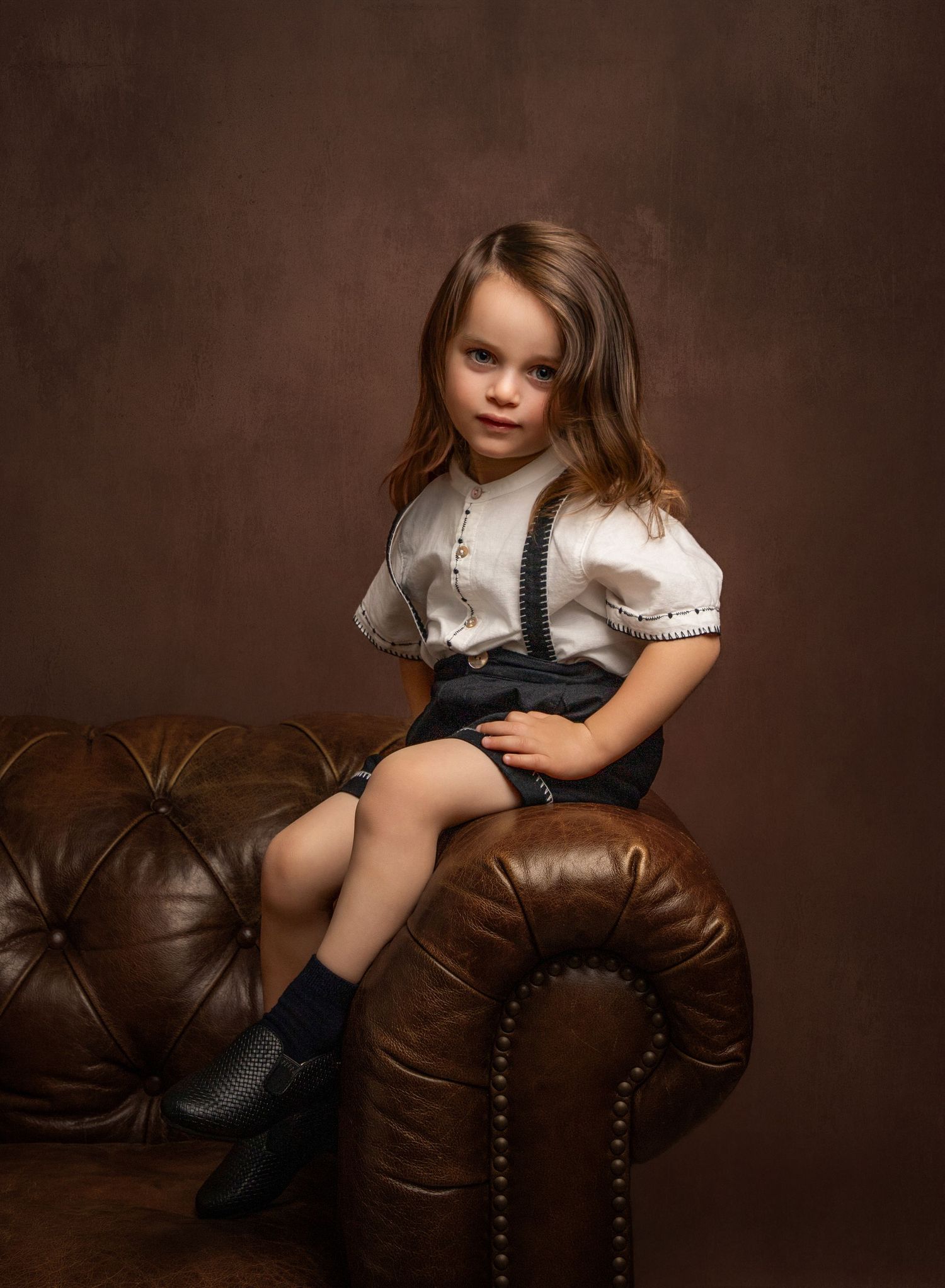 Fine art portrait of a boy on a vintage sofa.
