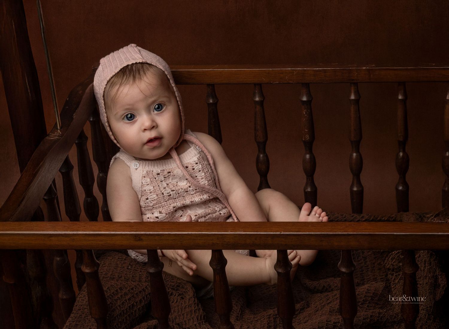 portrait of a baby ina  vintage cot.
