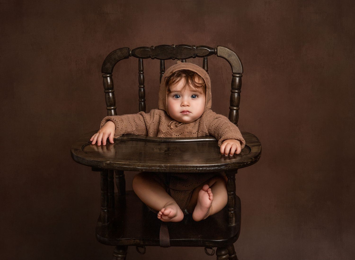 Fine art portrait of a baby in a vintage highchair.