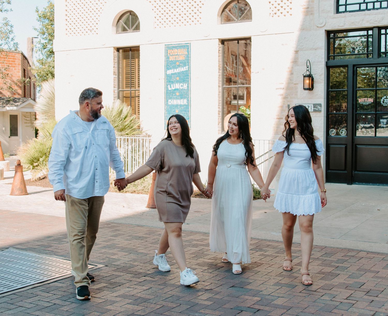 San Antonio Family Photography. Group walking together on brick pathway in front of historic building.