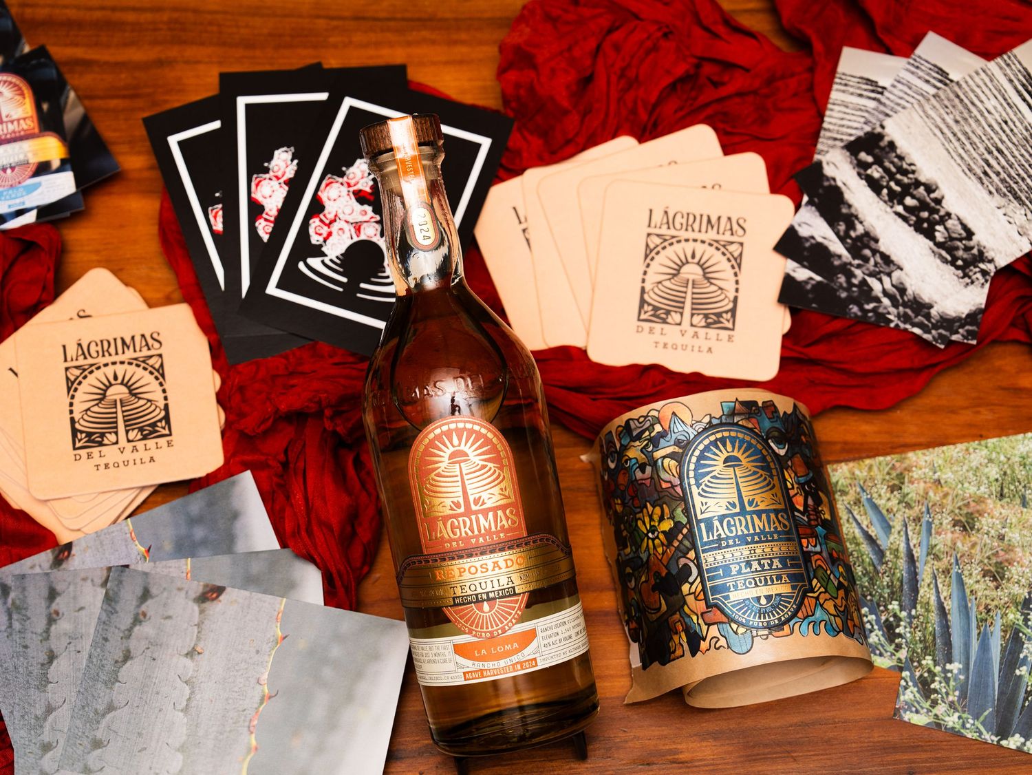 Bottles of Lagunitas craft beer and branded coasters arranged on a wooden surface with red fabric background.