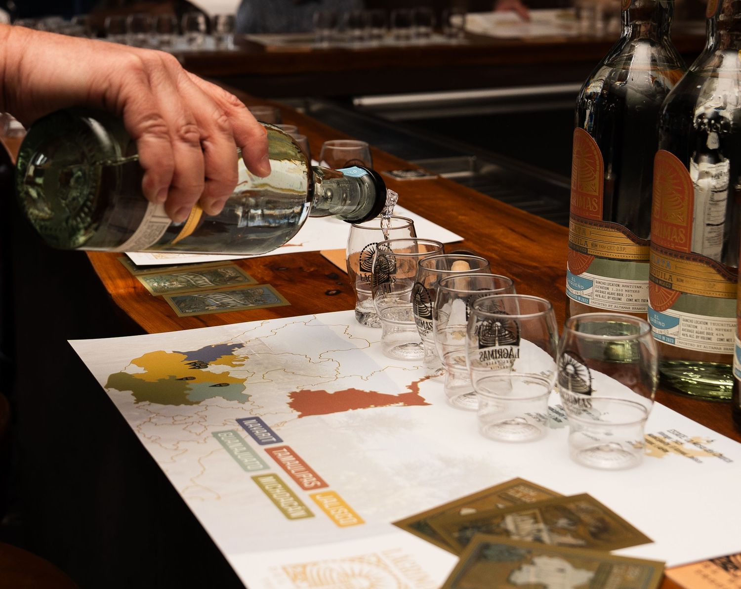 A series of hands pouring and tasting beverages at what appears to be a wine or spirit tasting event.